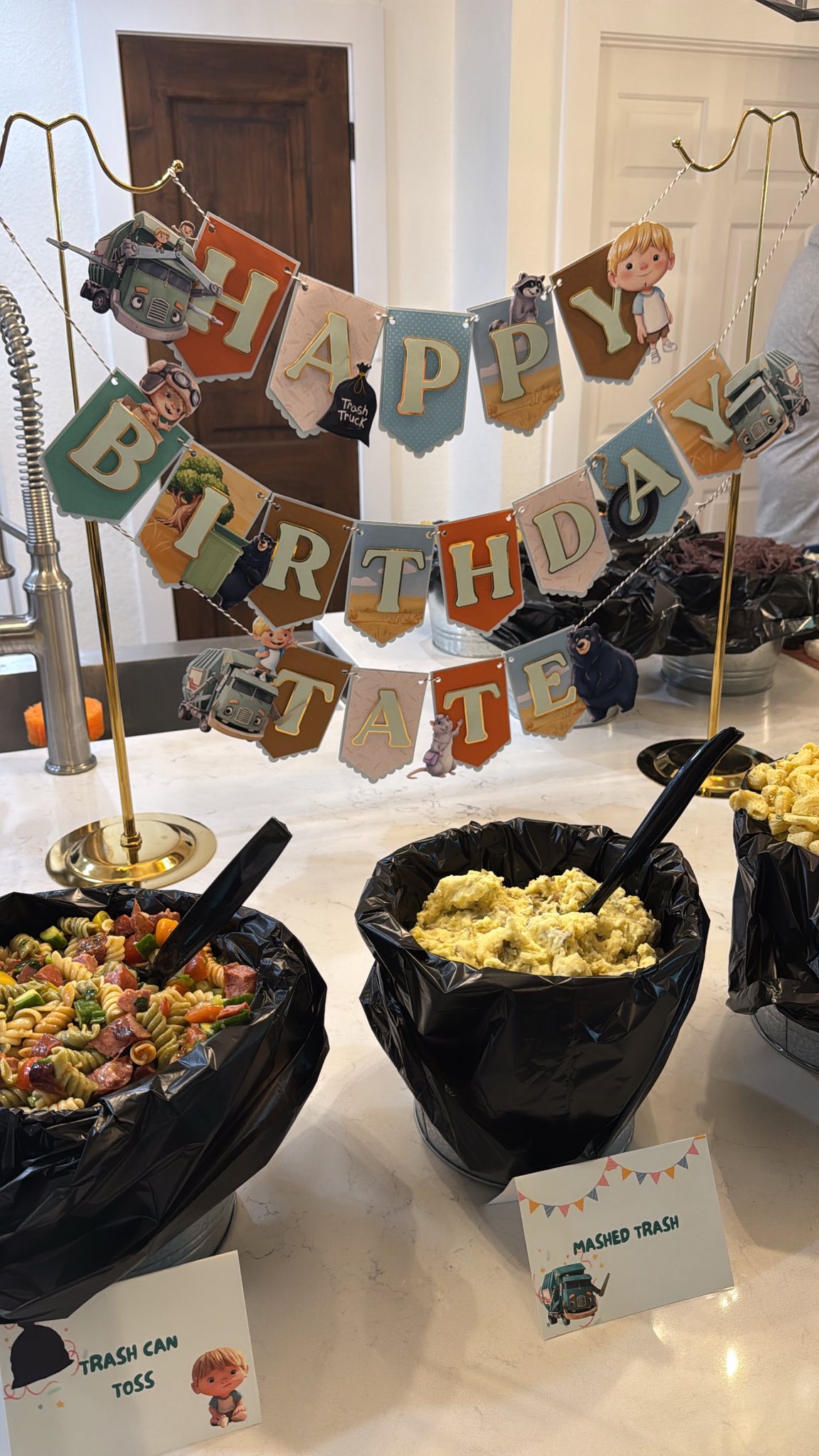 Trash Truck themed birthday party decorations featuring a Happy Birthday Tate banner and labeled food bowls