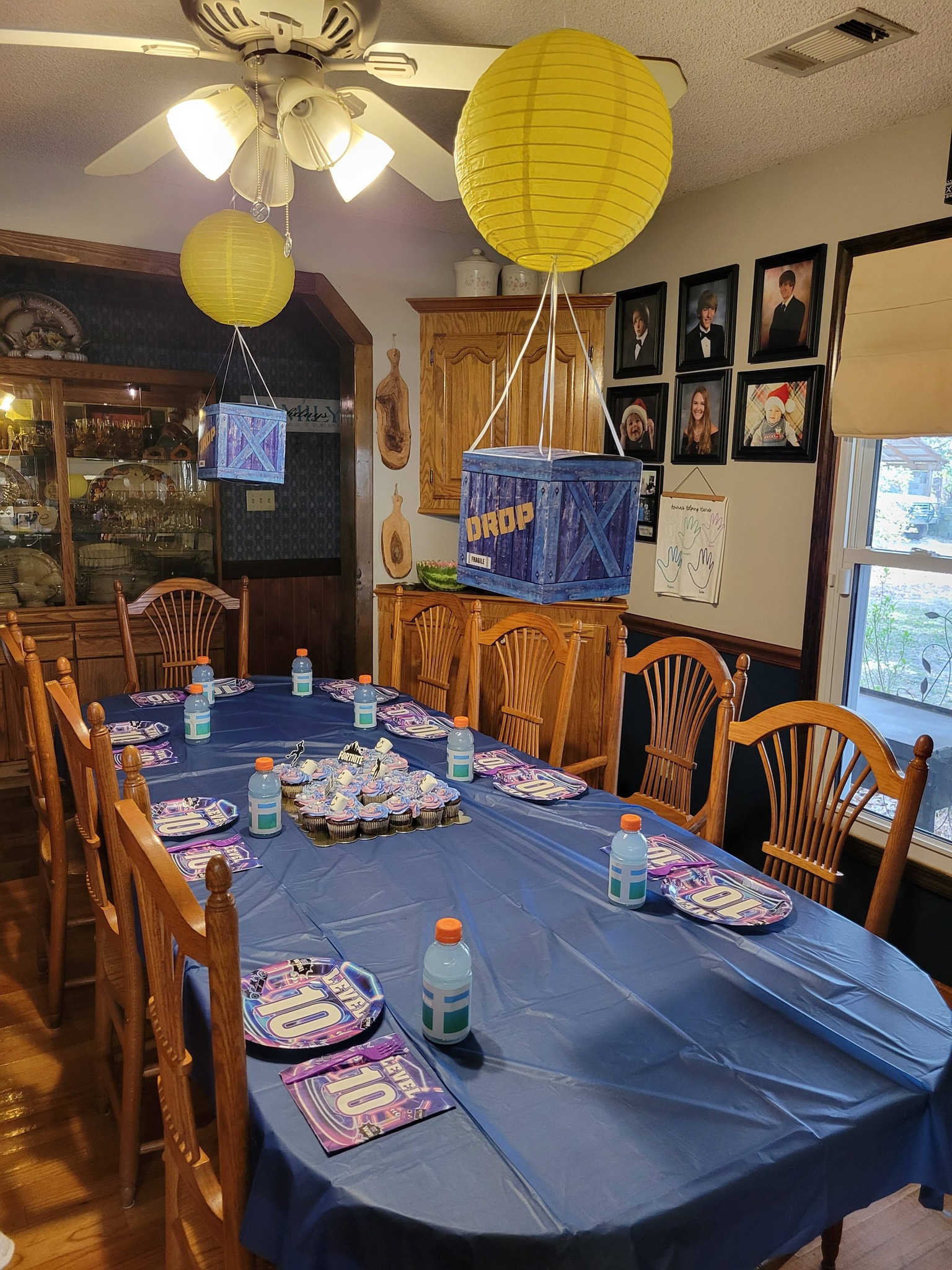 Table set for a video game themed 10th birthday party with Fortnite supply drop decorations.