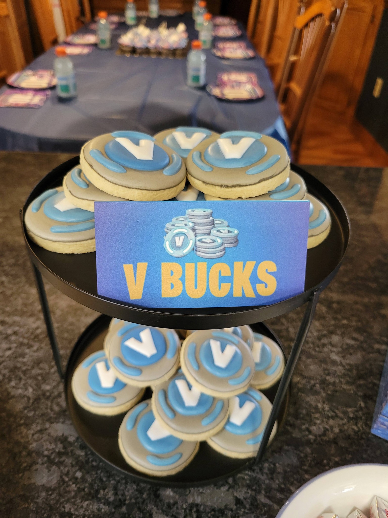 Two-tier tray filled with Fortnite V-Bucks themed cookies at a party
