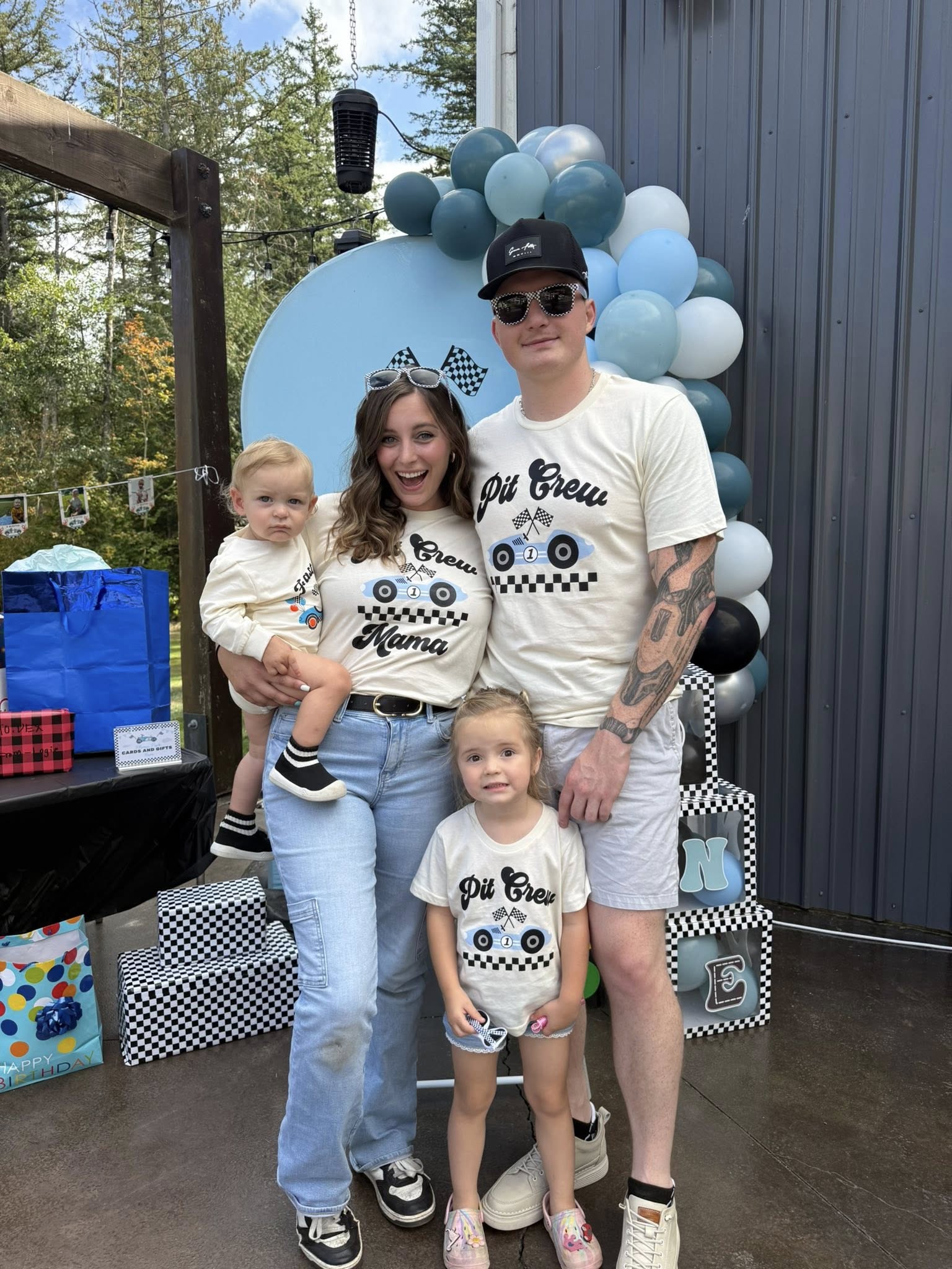 Family of four wearing matching cream Pit Crew race car theme t-shirts at a birthday party