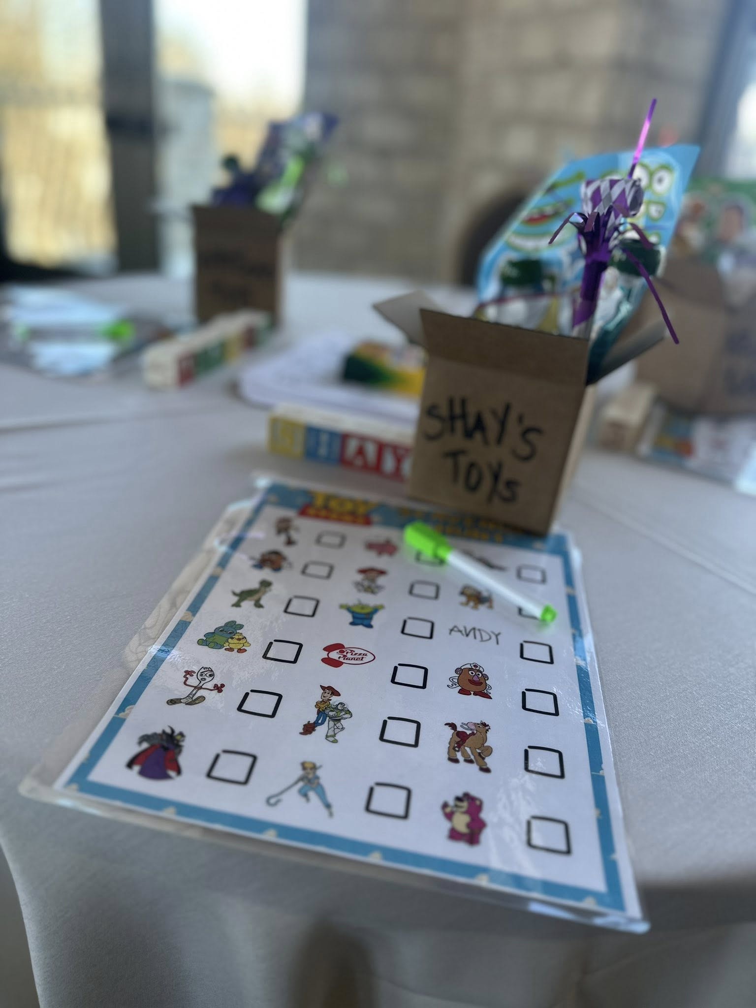 Toy Story character scavenger hunt checklist with a marker and a box labeled Shay's Toys.