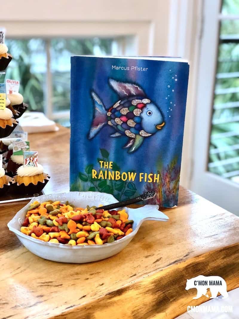 The Rainbow Fish book displayed next to a fish-shaped bowl filled with colorful goldfish crackers.