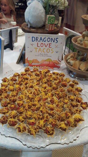 Platter of mini tacos arranged on a table with a Dragons Love Tacos book for a themed party.