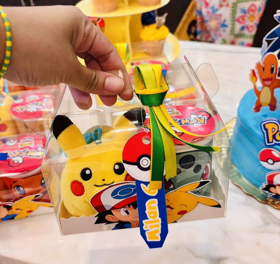 Clear party favor box featuring Pikachu and Ash Ketchum with a personalized name tag for a Pokemon birthday party.