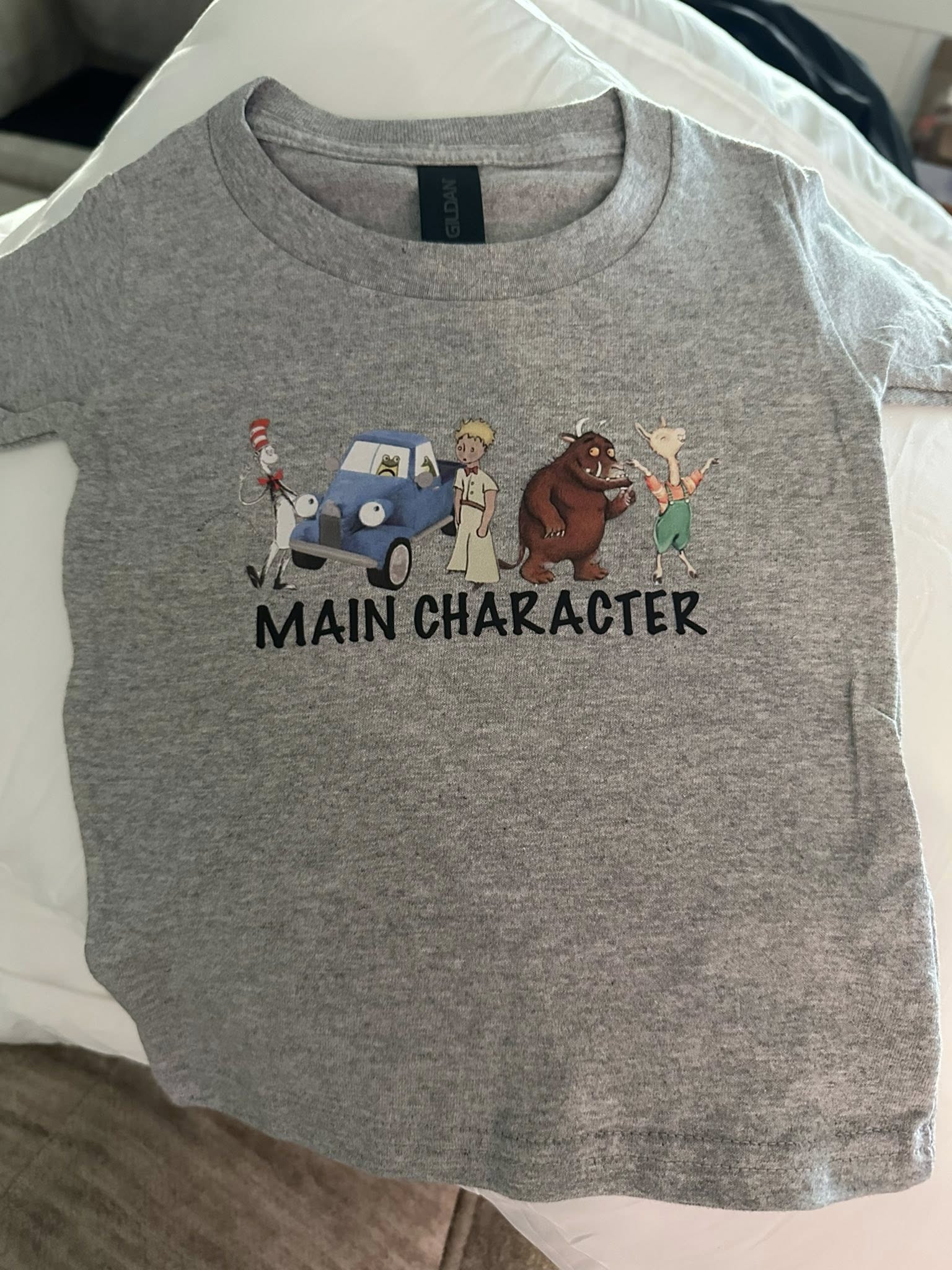 Grey toddler t-shirt featuring literary characters and the text Main Character.
