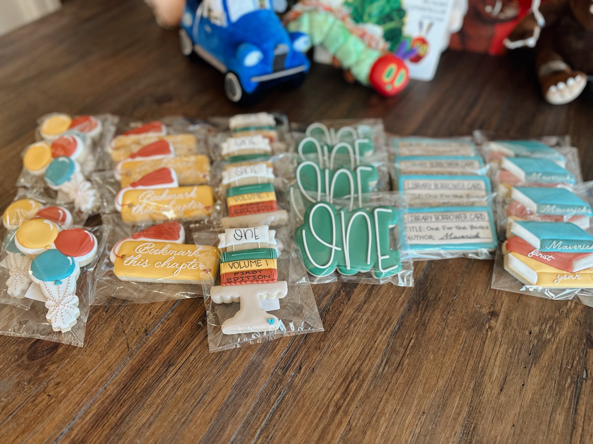 Assorted book and library-themed sugar cookies for a first birthday party, including bookmark and book stack designs.