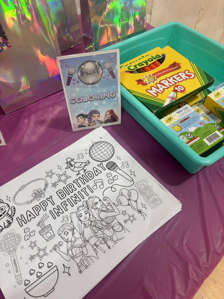 Table with a personalized Happy Birthday coloring sheet, a bin of Crayola markers, and a coloring station sign.