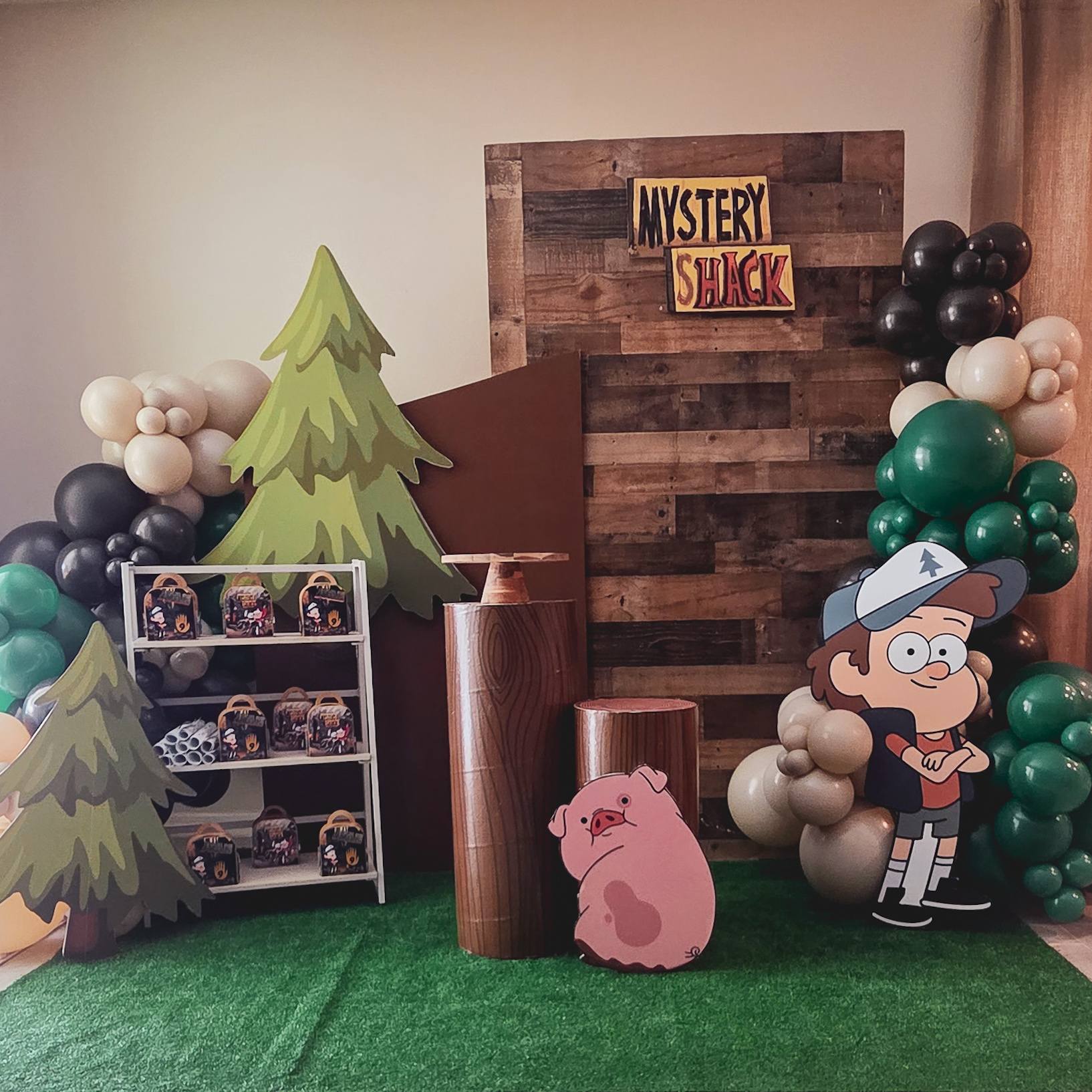Gravity Falls themed party backdrop with Mystery Shack sign, Dipper Pines cutout, and balloon arch.