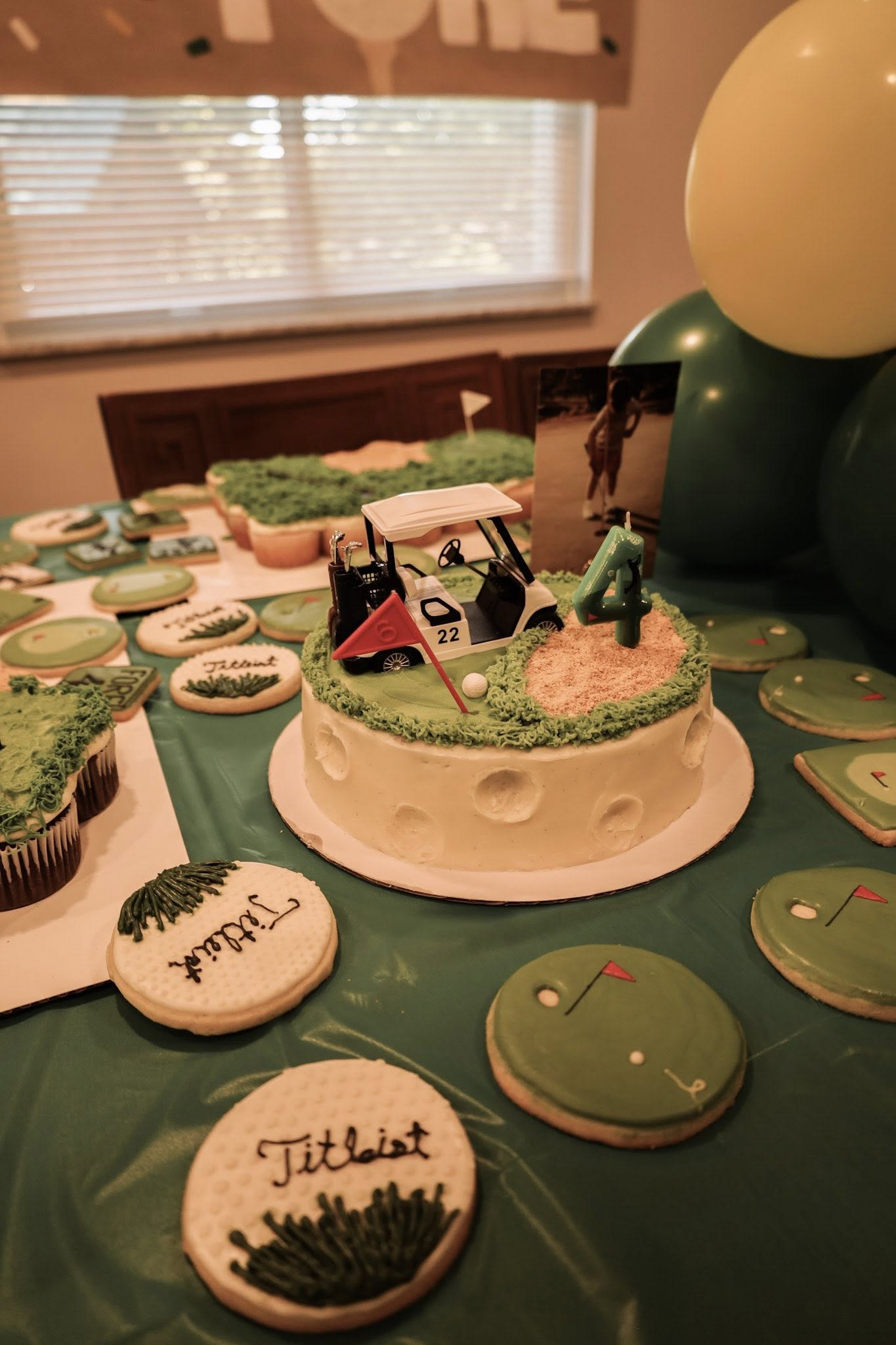 Golf-themed birthday cake topped with a miniature golf cart, sand trap, and a number 4 candle.