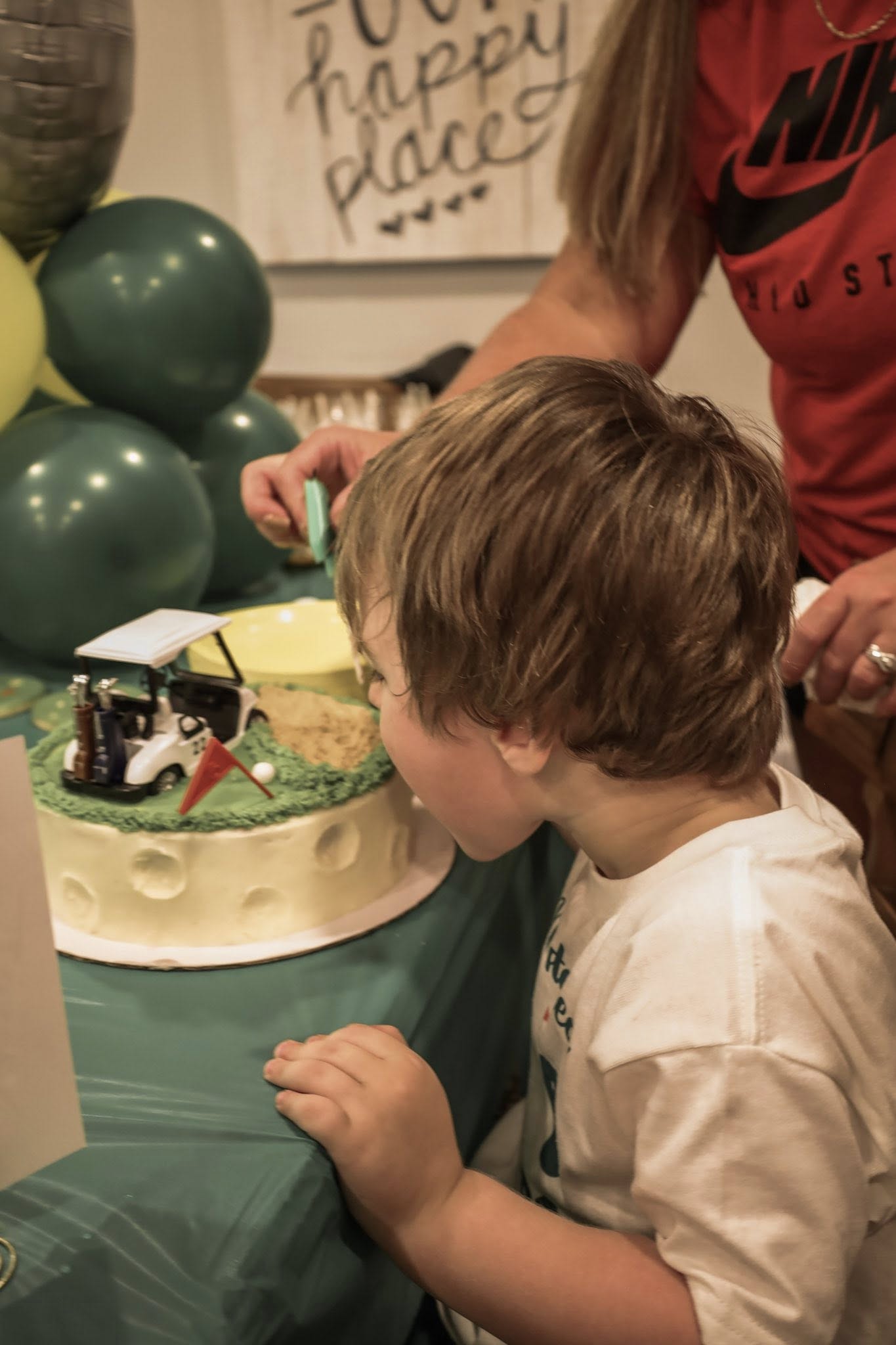 Young boy looking at a golf-themed birthday cake