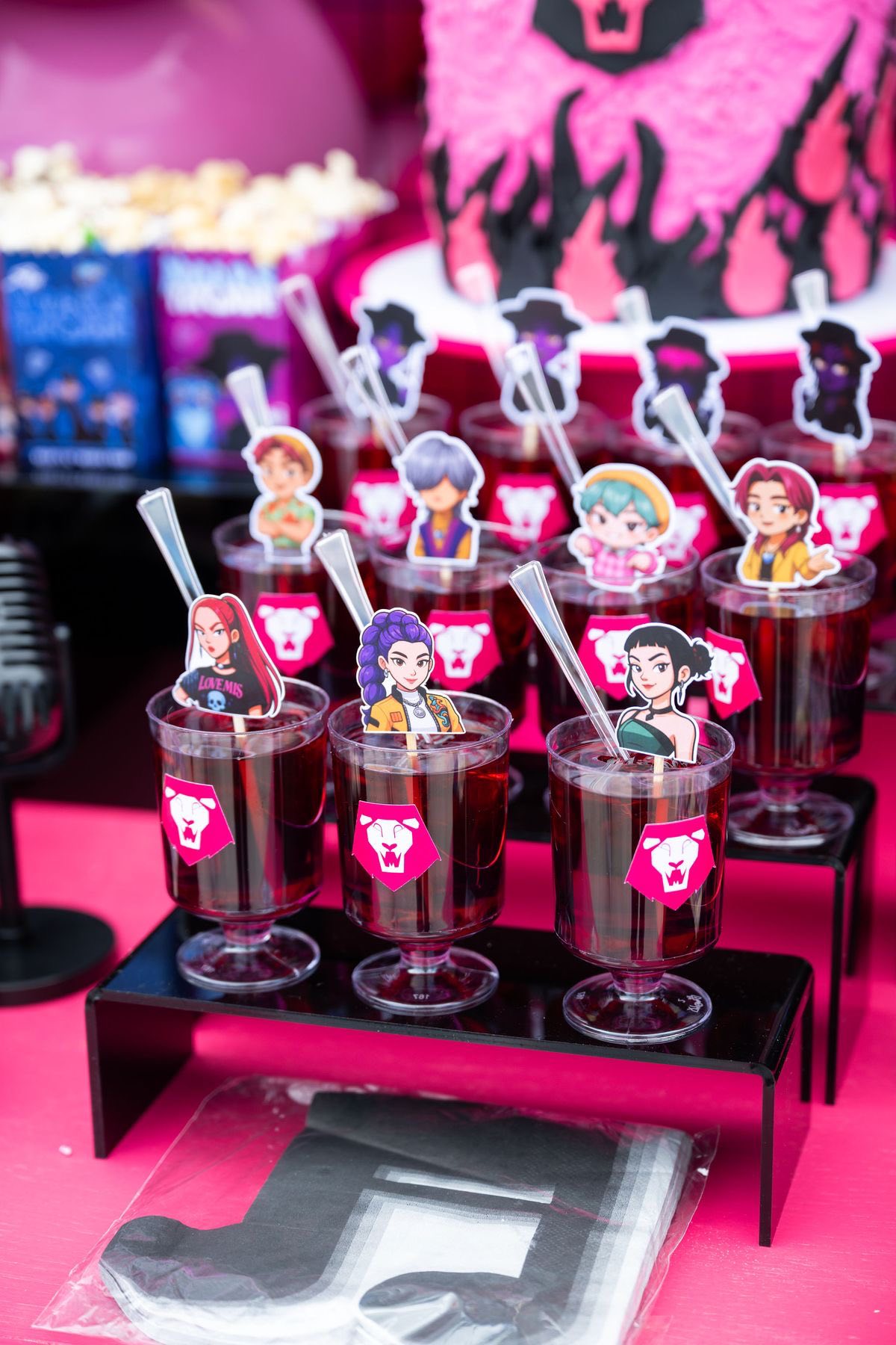 Drinks with anime character toppers served in clear cups at a themed party