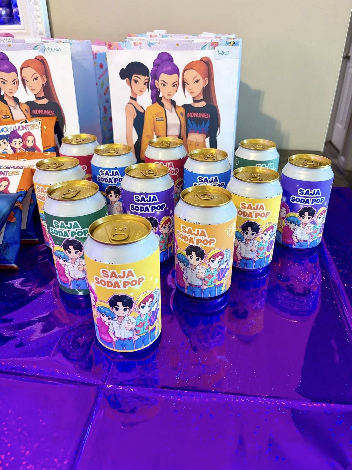 Group of Saja Soda Pop cans displayed on a purple glittery surface with anime style packaging.