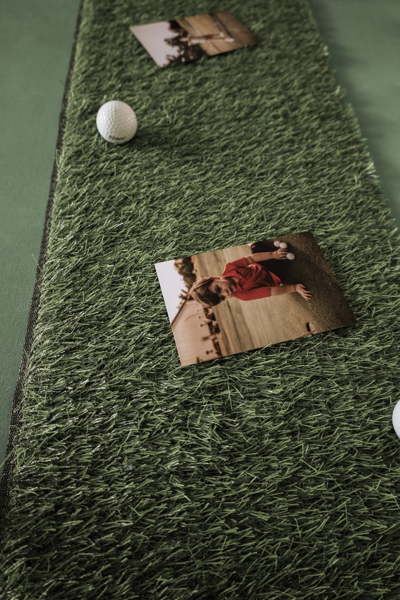 Indoor putting green mat with golf balls and a photograph of a child playing golf.
