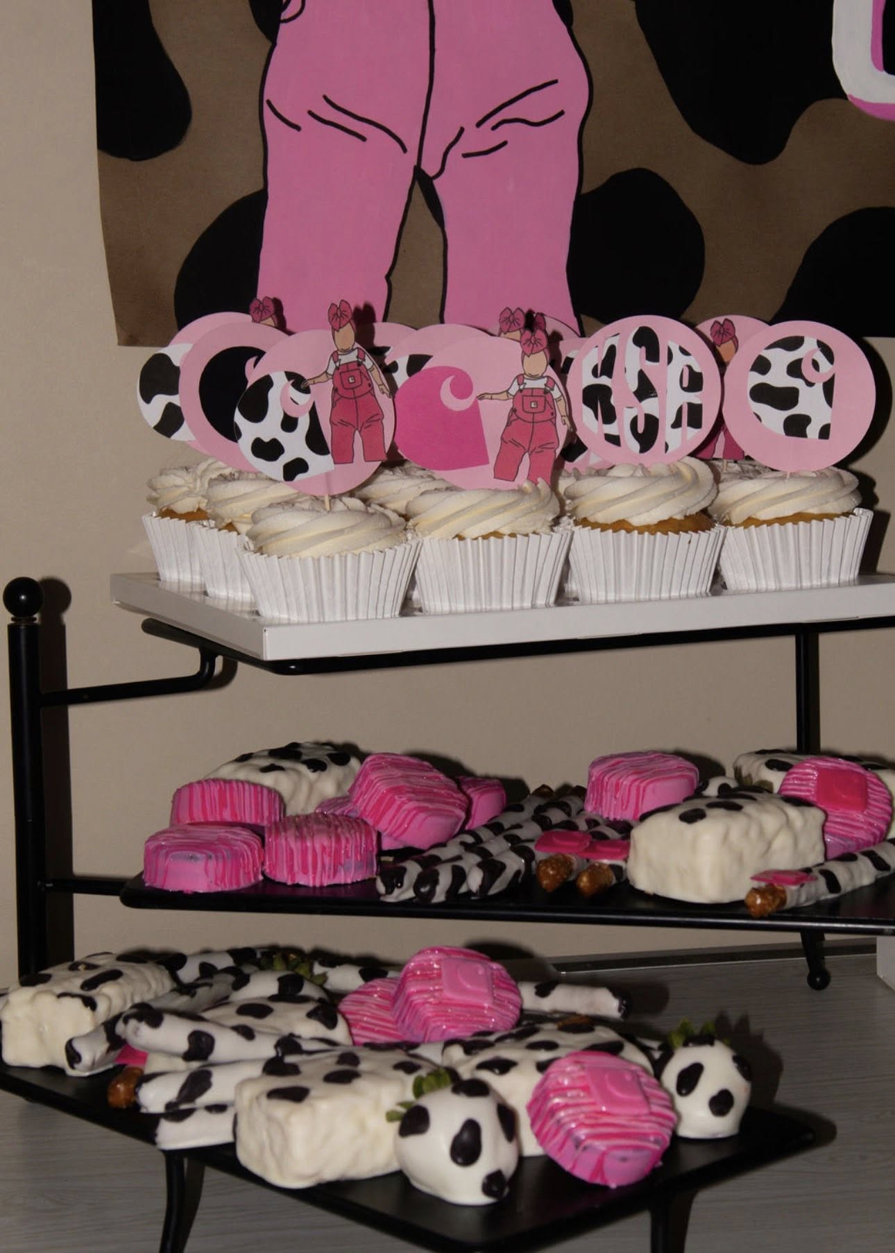 Cupcakes and treats decorated with pink accents and cow print theme for a party