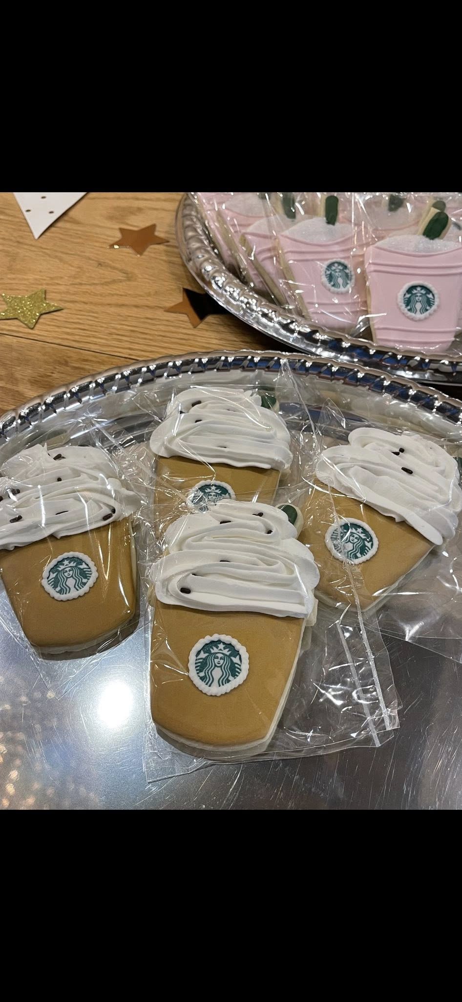 Individually wrapped cookies decorated to look like coffee frappes with Starbucks logos and whipped cream frosting