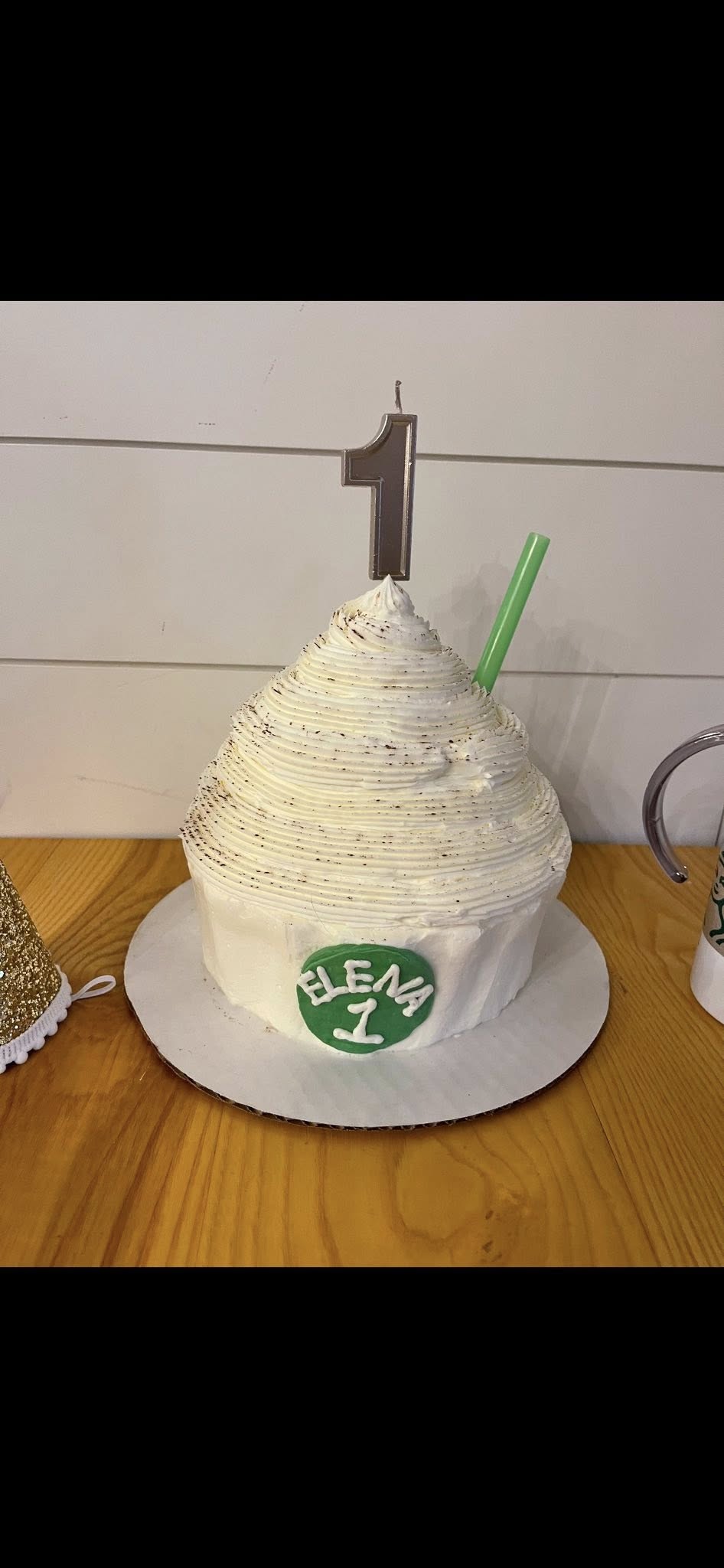 First birthday smash cake frosted with white icing and a number one candle on top