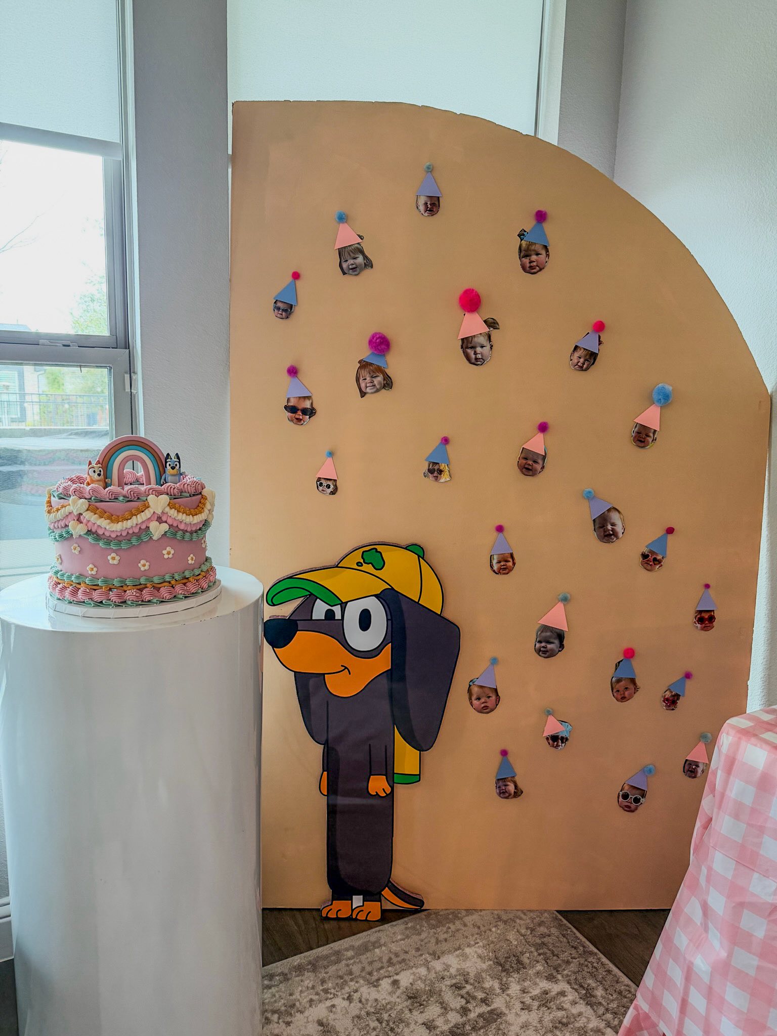 Bluey themed birthday cake and cutout with a photo party backdrop on a pedestal