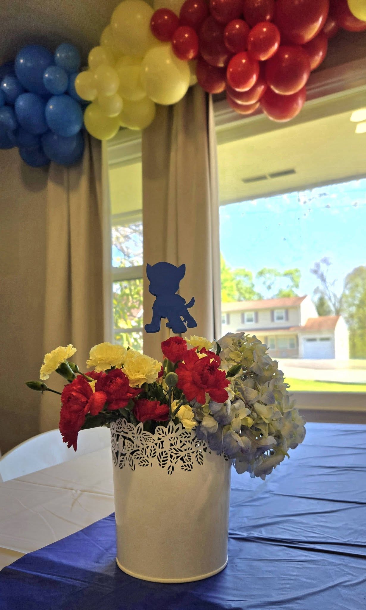 Paw Patrol theme floral centerpiece with a blue puppy cutout in a white decorative vase