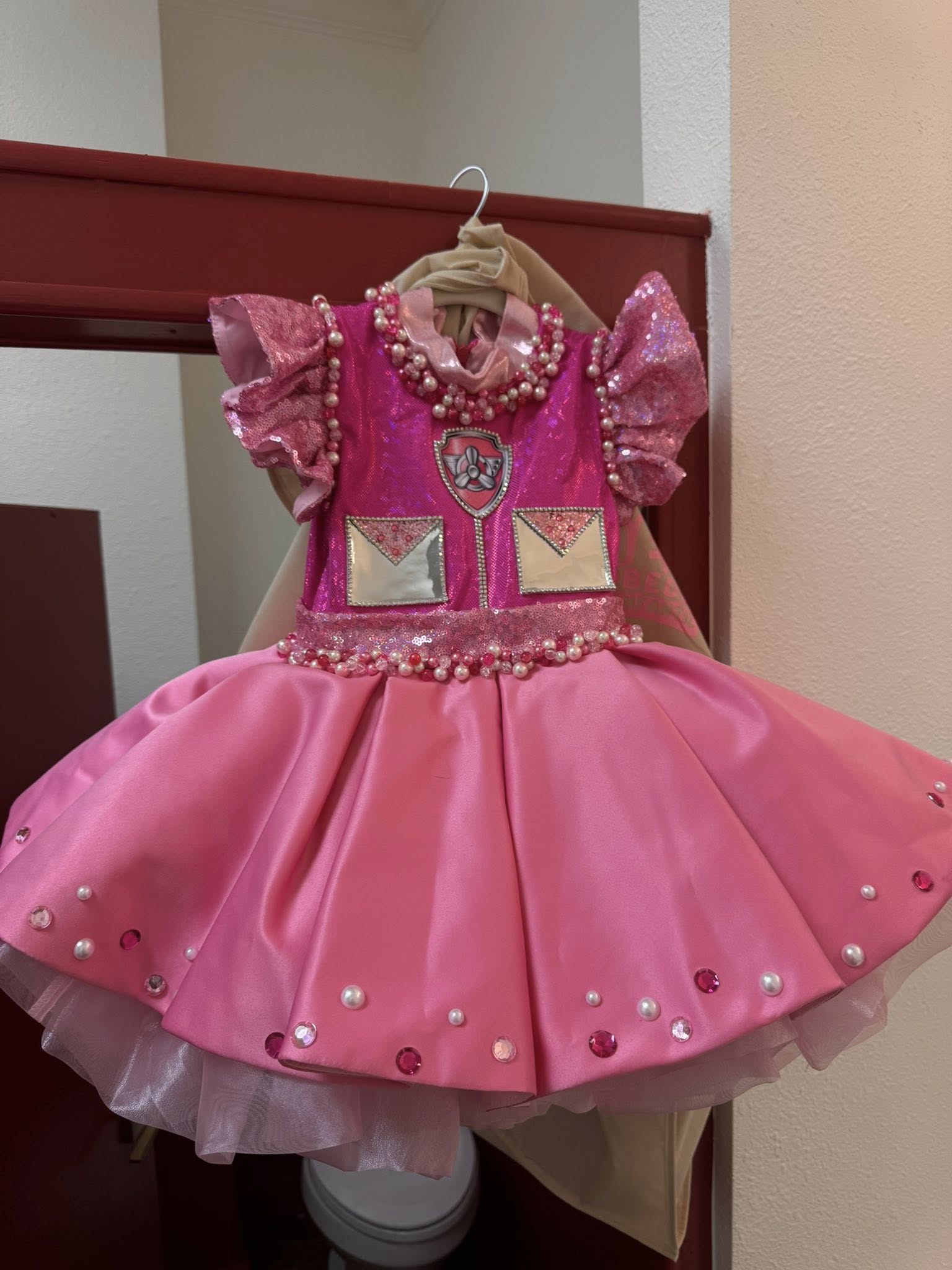 Toddler-sized pink Paw Patrol themed pageant dress with sequins, pearls, and a satin skirt.