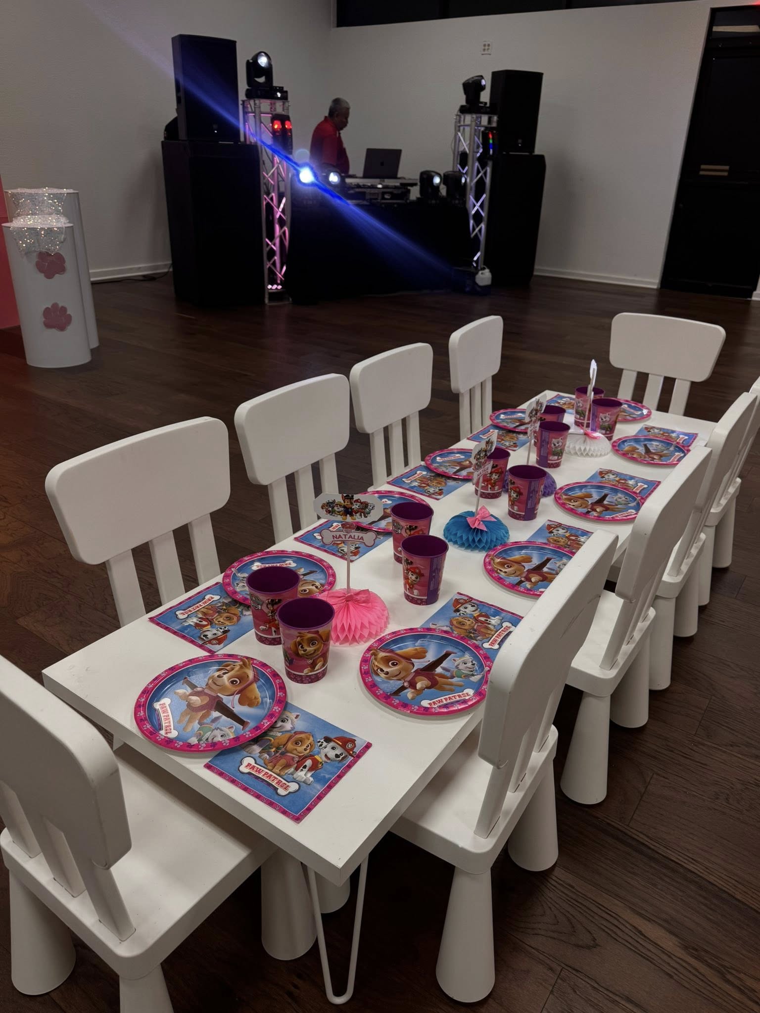 Table set for a child's birthday party with Paw Patrol themed paper plates, cups, and napkins.
