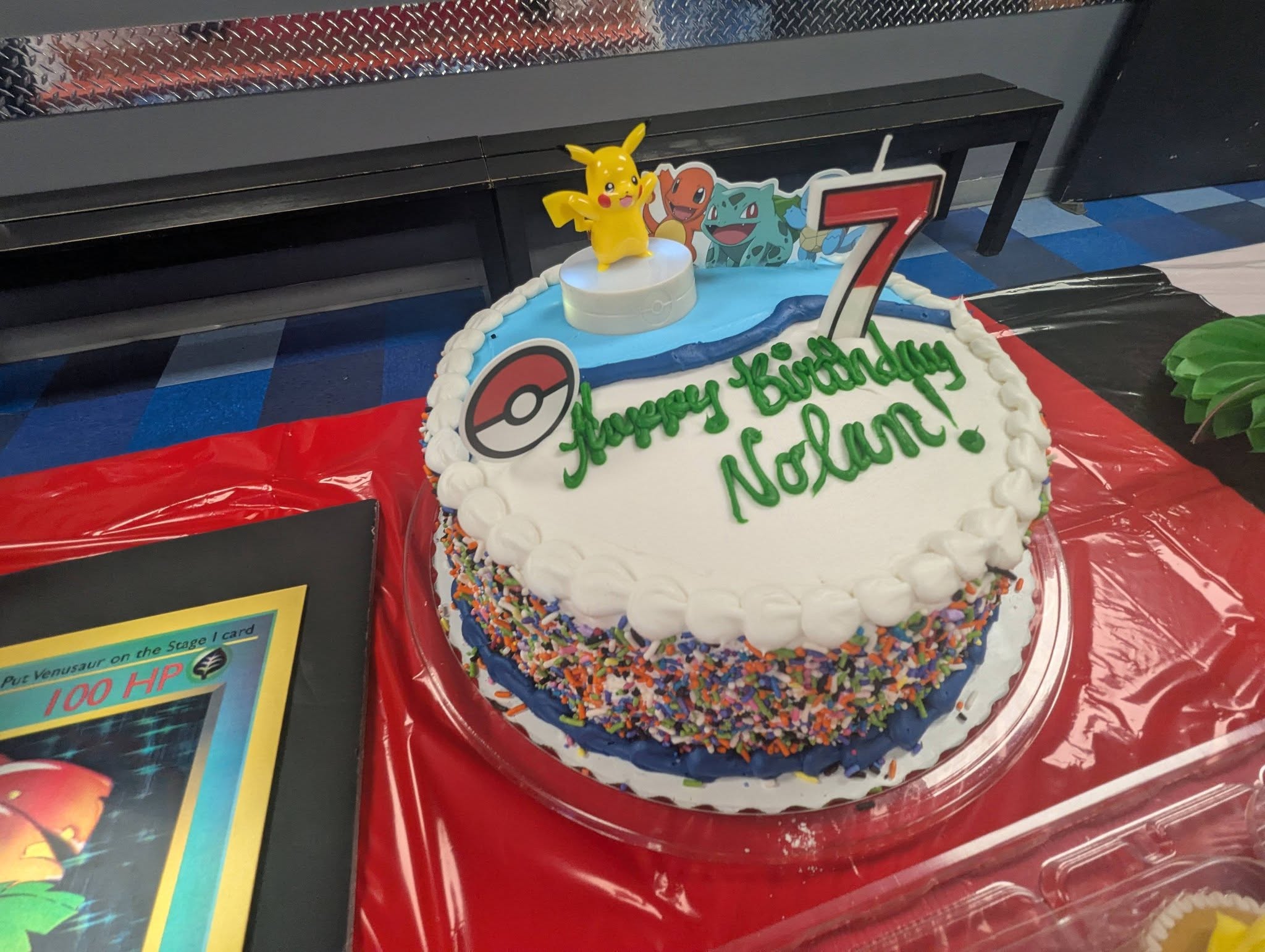 Pokemon themed birthday cake for a 7th birthday personalized with Happy Birthday Nolan and Pikachu topper.