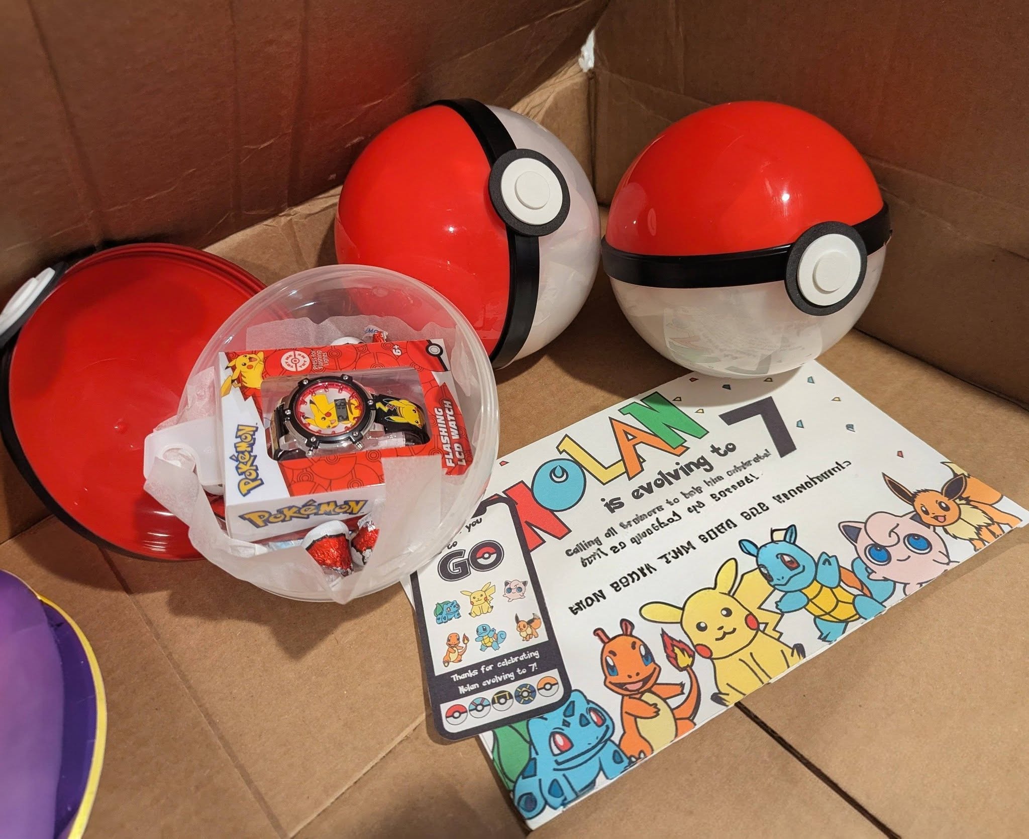 Pokemon themed birthday gift set including plastic Poke Balls, a Pikachu LCD watch, and a custom Pokemon invitation card