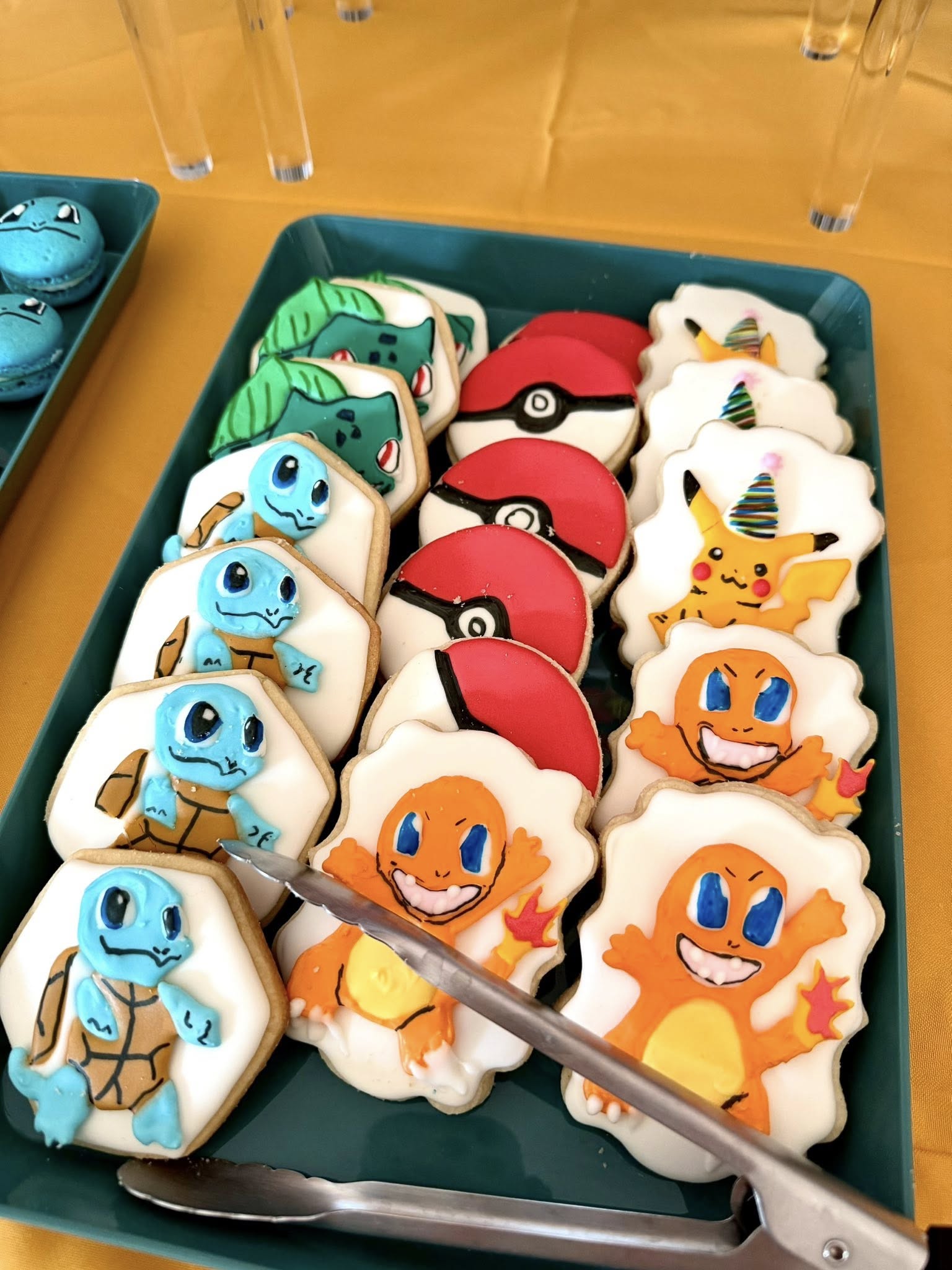 Tray of decorated sugar cookies featuring Pikachu, Charmander, Squirtle, Bulbasaur, and Poké Balls.