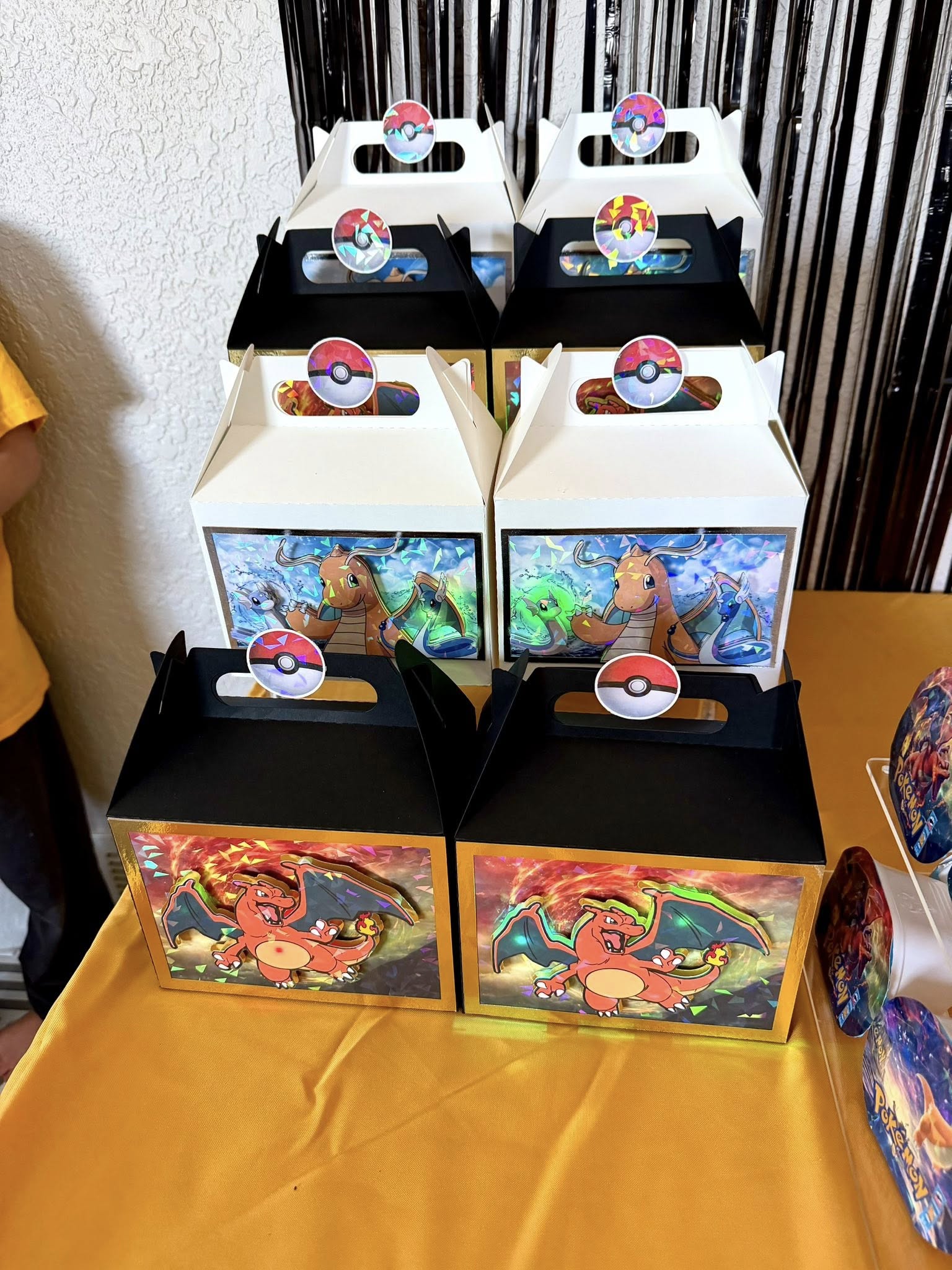 Group of Pokemon-themed party favor boxes featuring Charizard and Dragonite with holographic accents