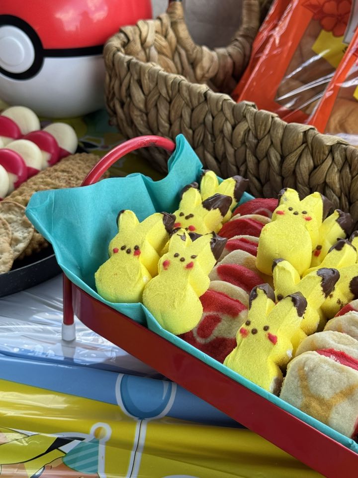 Tray of yellow Pikachu-shaped marshmallow treats arranged with red and white cookies