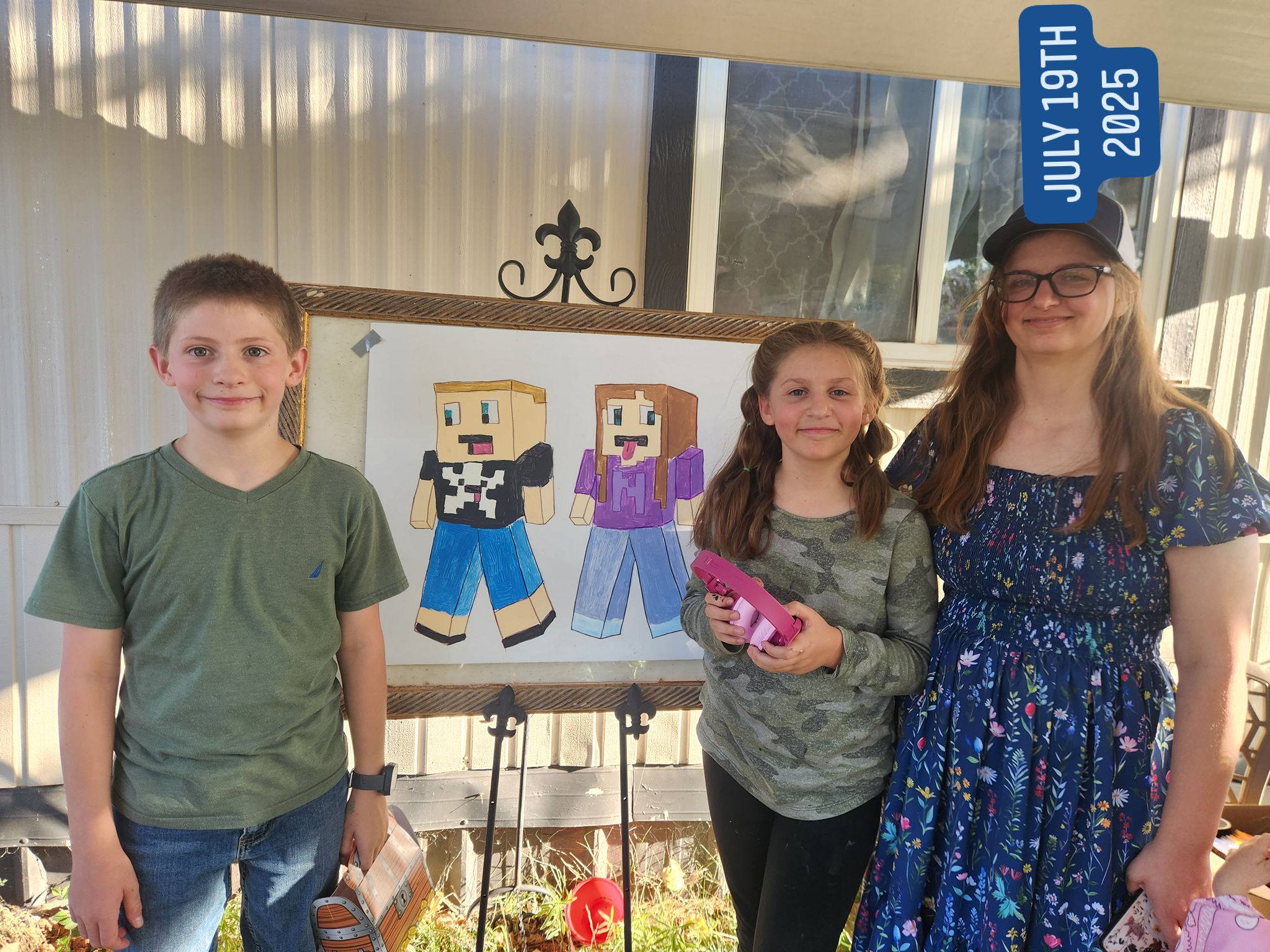 Three children standing in front of a poster featuring hand-drawn Minecraft-style character illustrations.