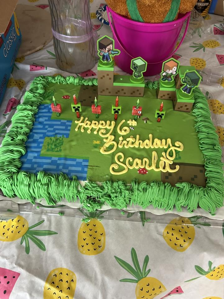Rectangular Minecraft themed birthday cake for Scarlet's 6th birthday with character toppers and candles.