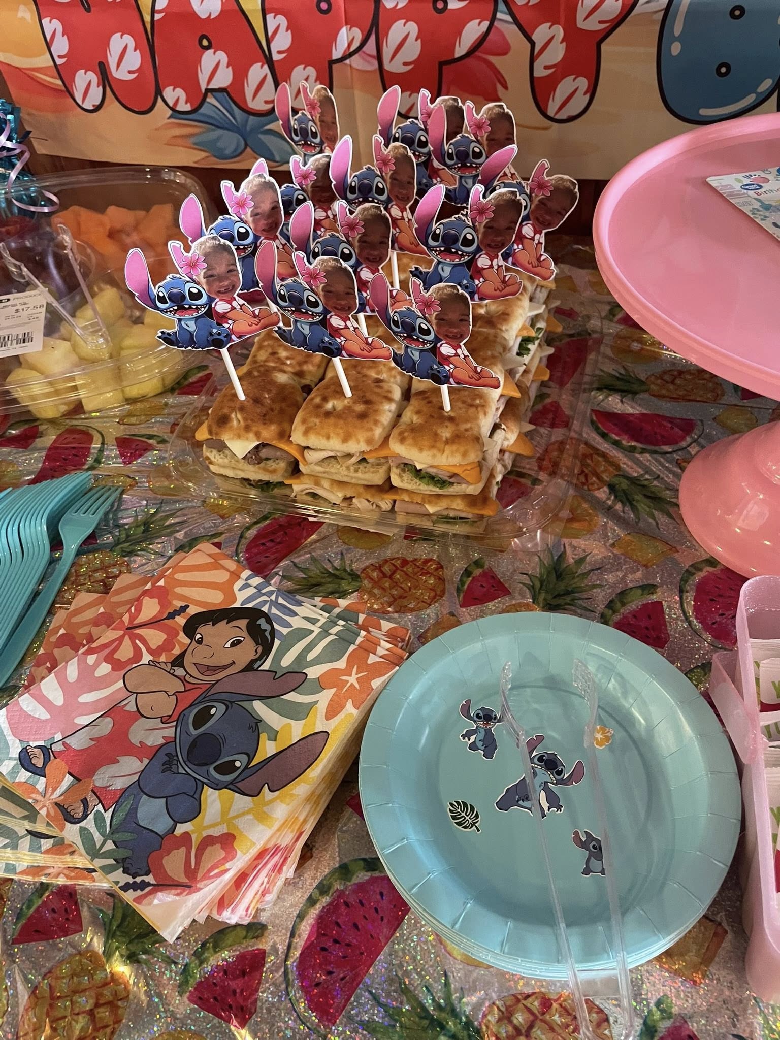 Sliders decorated with custom Stitch and child photo cupcake toppers for a Lilo and Stitch themed birthday party.