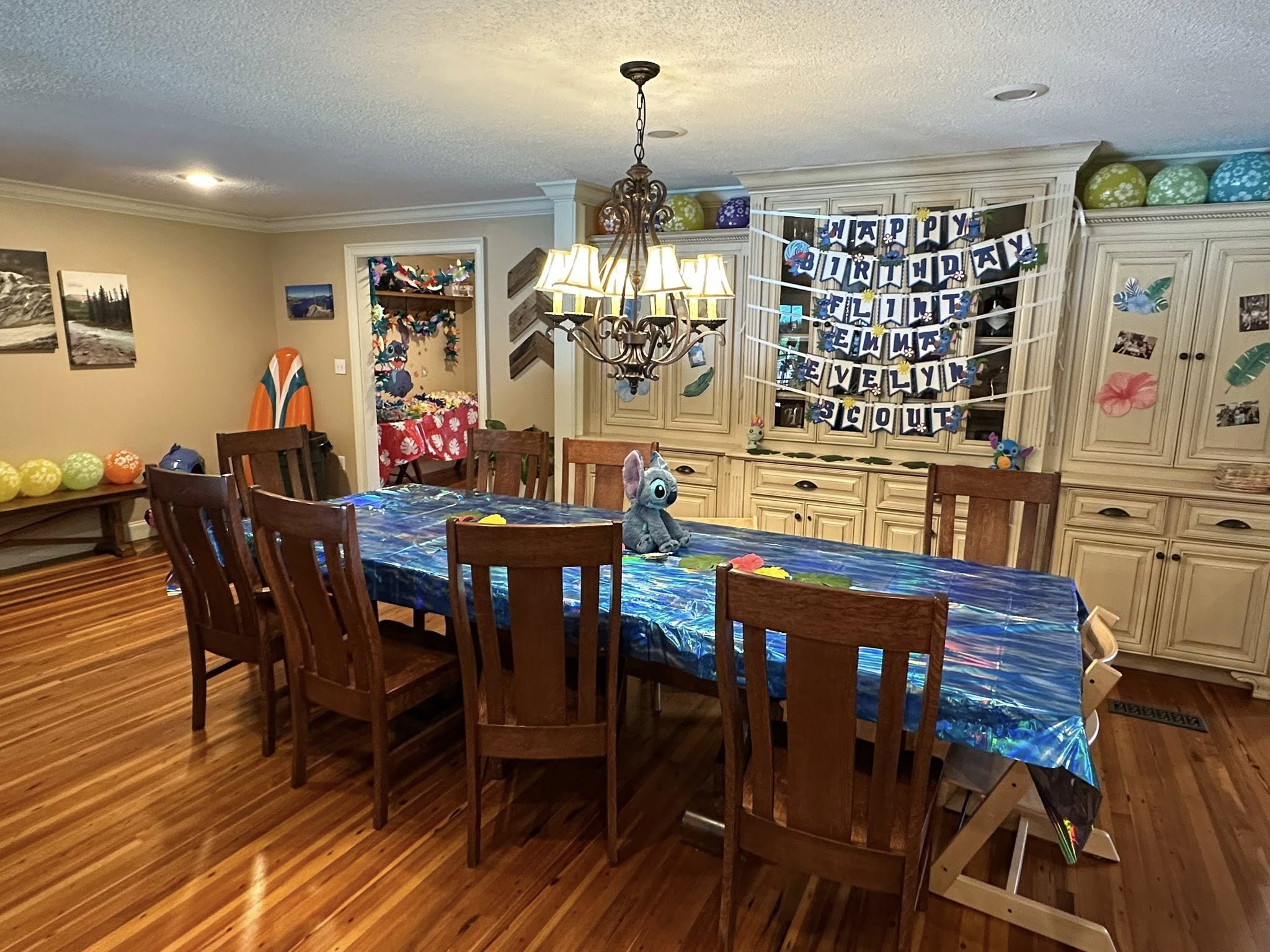 Dining room decorated for a Lilo and Stitch themed birthday party with blue table cover and character banner.