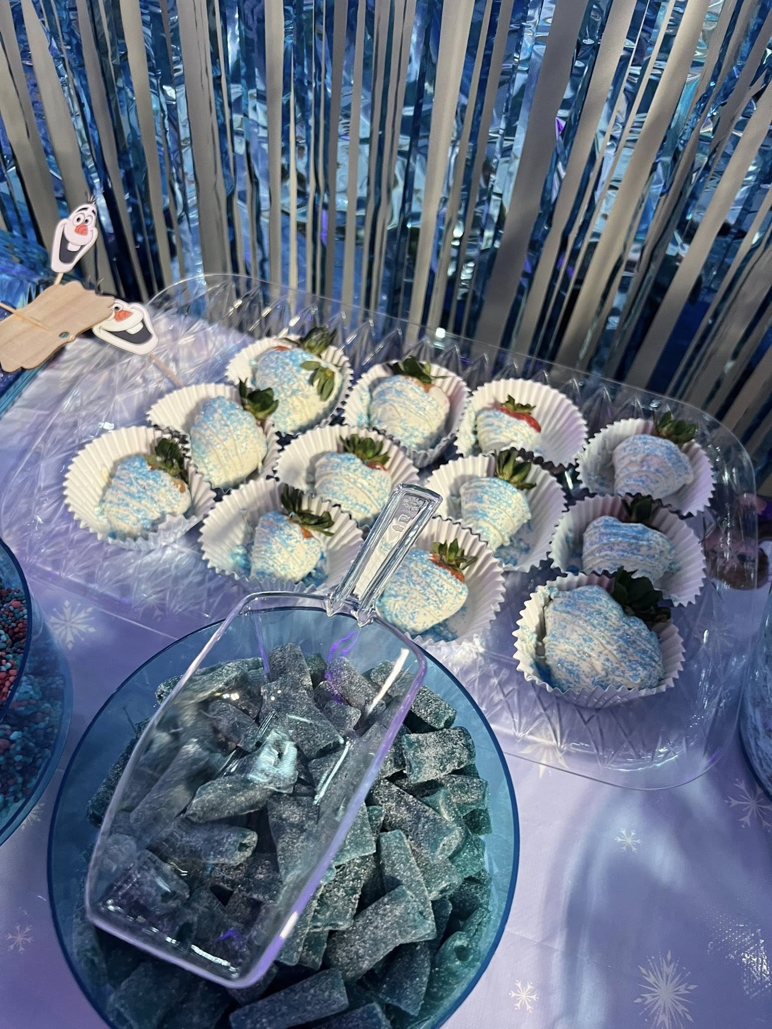 Tray of white chocolate dipped strawberries with blue sugar sprinkles for a Frozen themed party