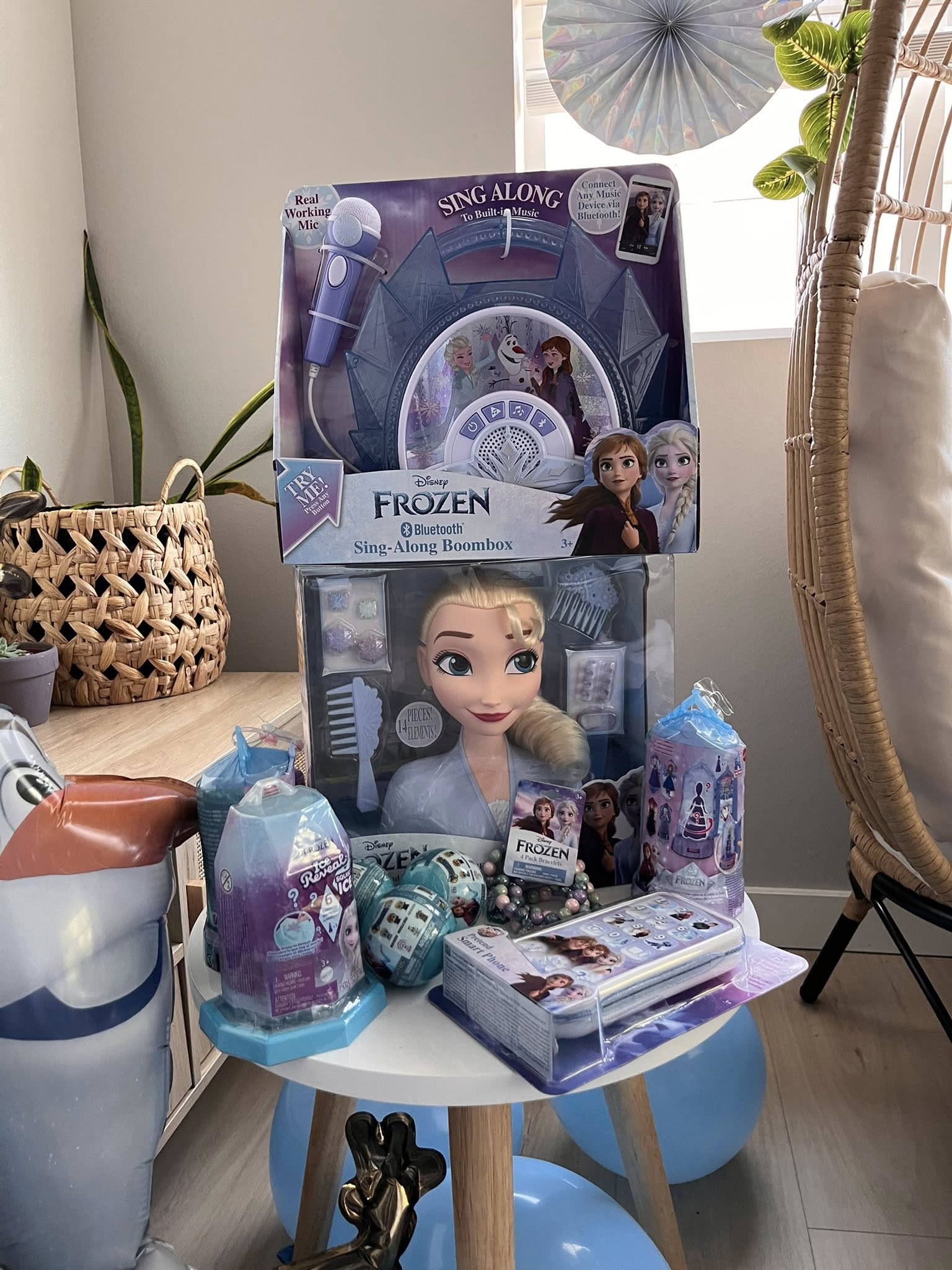 Disney Frozen branded toys including a sing-along boombox, Elsa styling head, and assorted small play accessories.