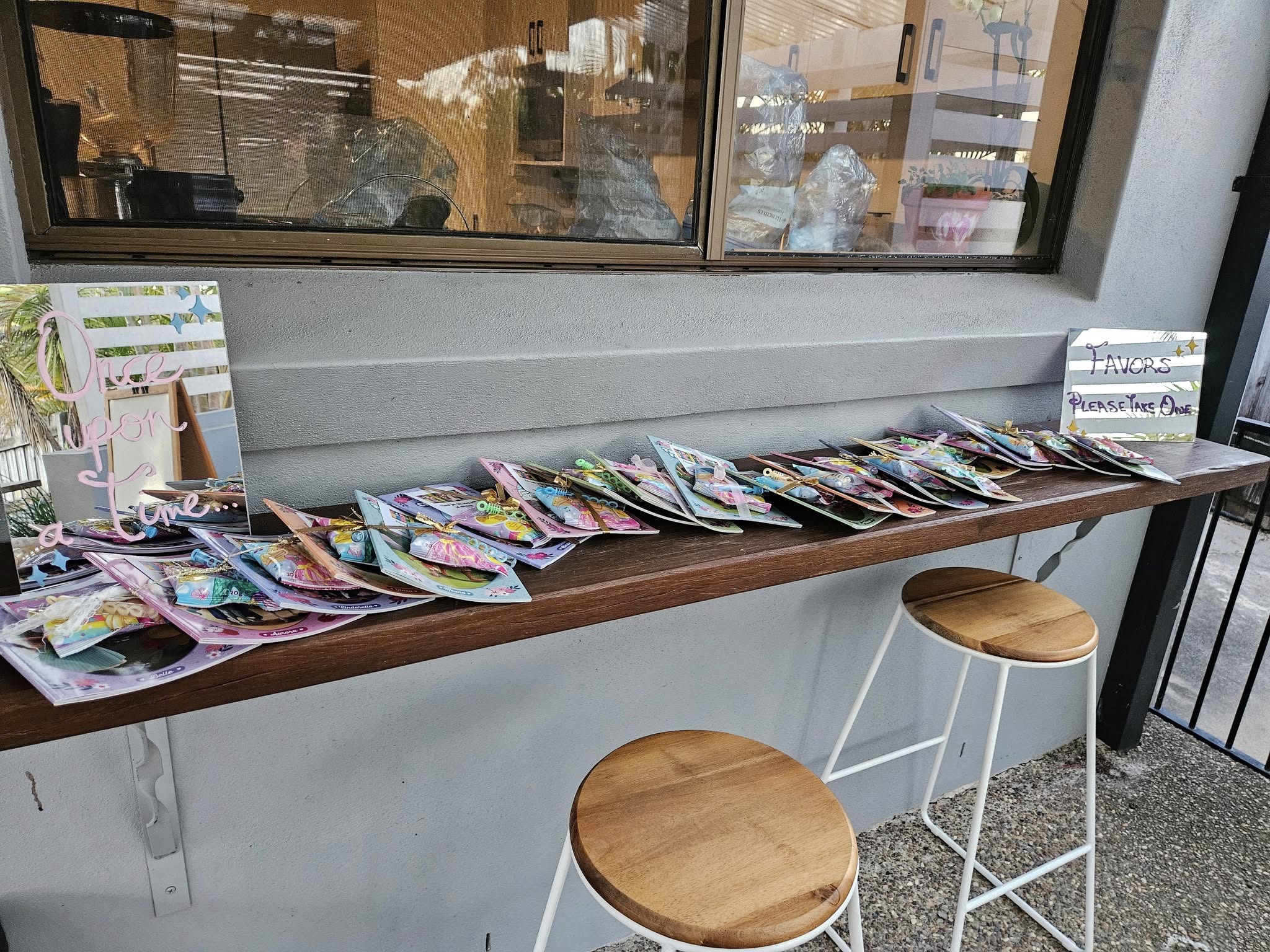 Table topped with party favor gift bags next to signs labeled Once upon a time and Favors Please Take One.