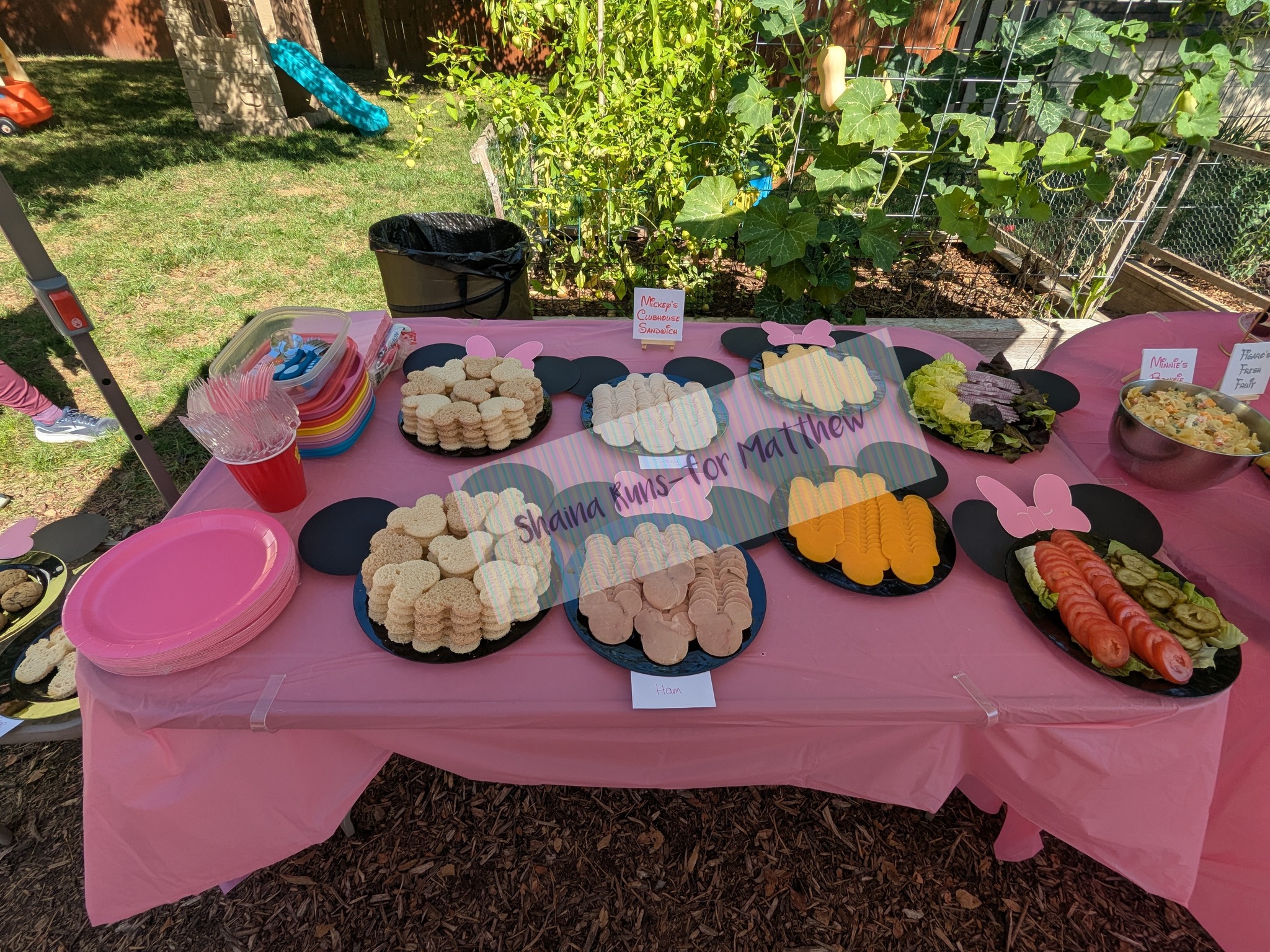 Mickey Mouse clubhouse themed snack table with sandwiches, meat, cheese, and vegetables for a party