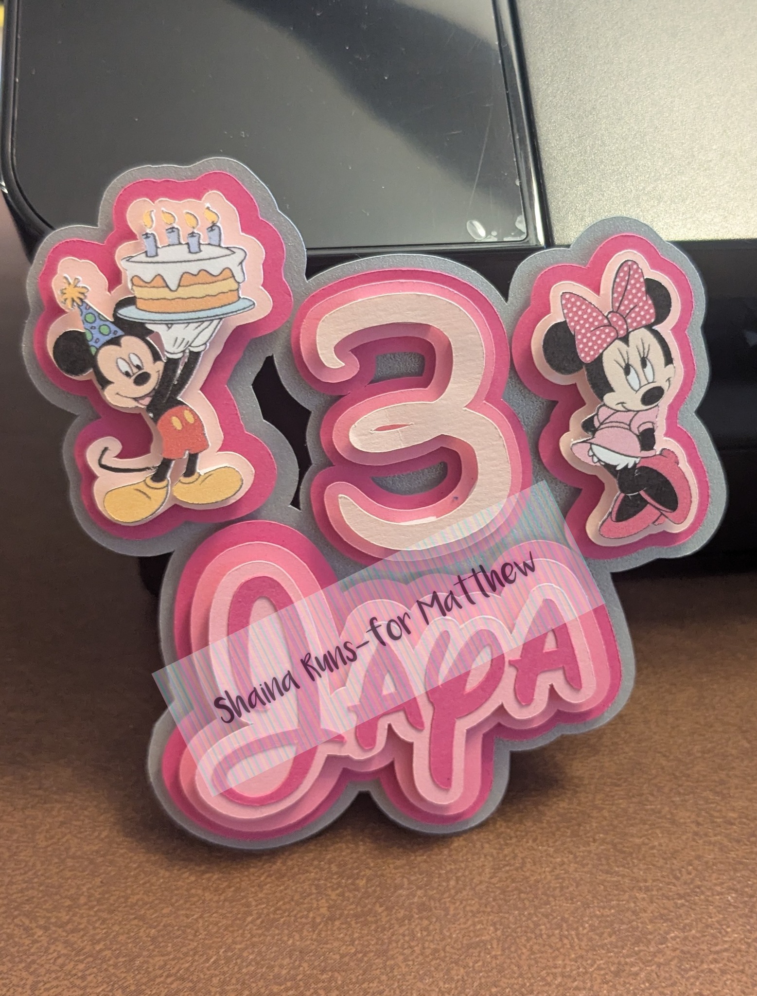 Mickey and Minnie Mouse themed third birthday cake topper in pink with layered paper cutout design.