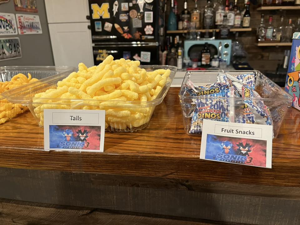 Sonic the Hedgehog 3 themed snack table featuring cheese puffs labeled Tails and fruit snacks.