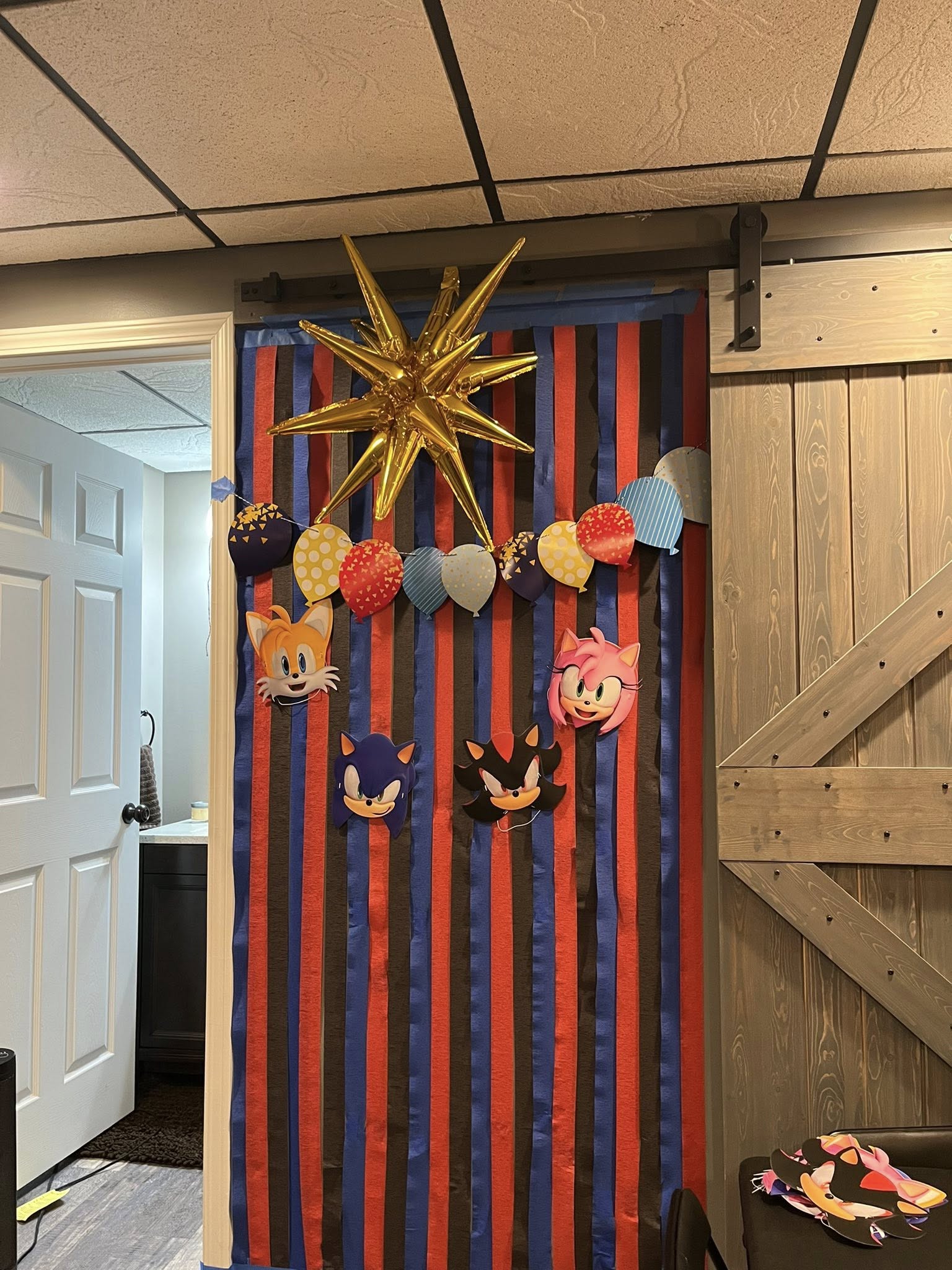 Sonic the Hedgehog themed party door decoration with paper character cutouts, balloon garland, and star balloon.