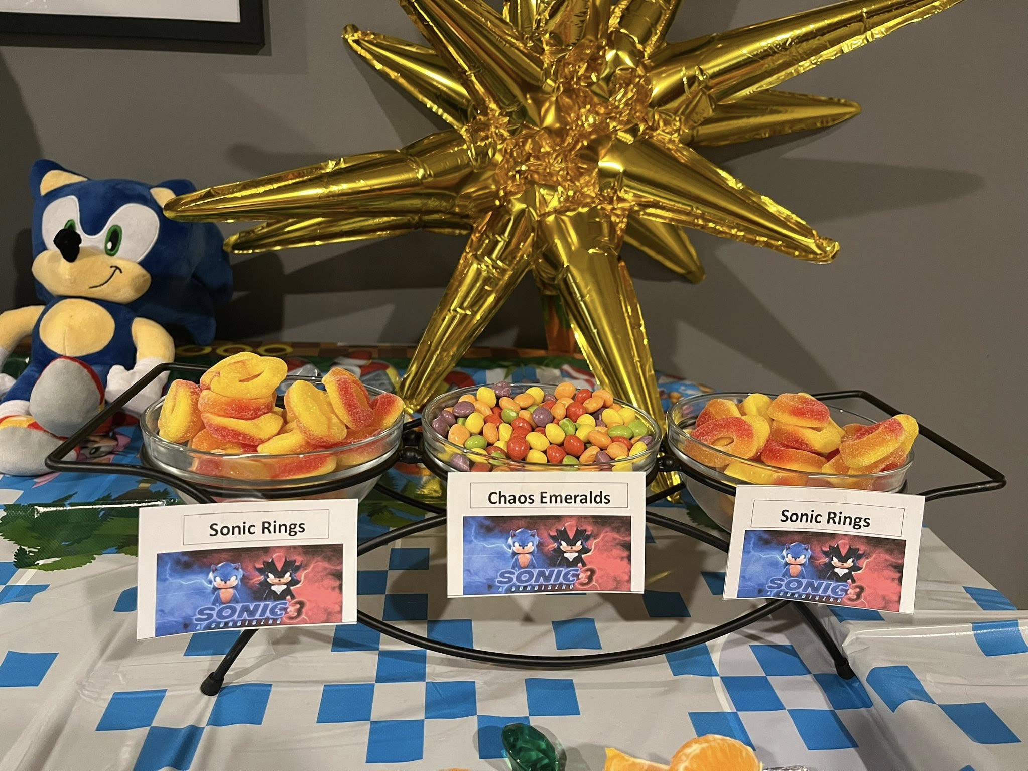 Sonic the Hedgehog themed party table with bowls of candy labeled Sonic Rings and Chaos Emeralds.