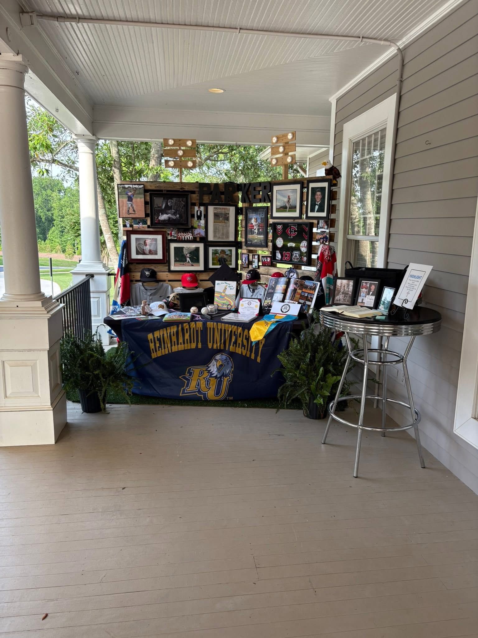 Table display featuring Reinhardt University memorabilia, photos, and personal items honoring a student named Parker.