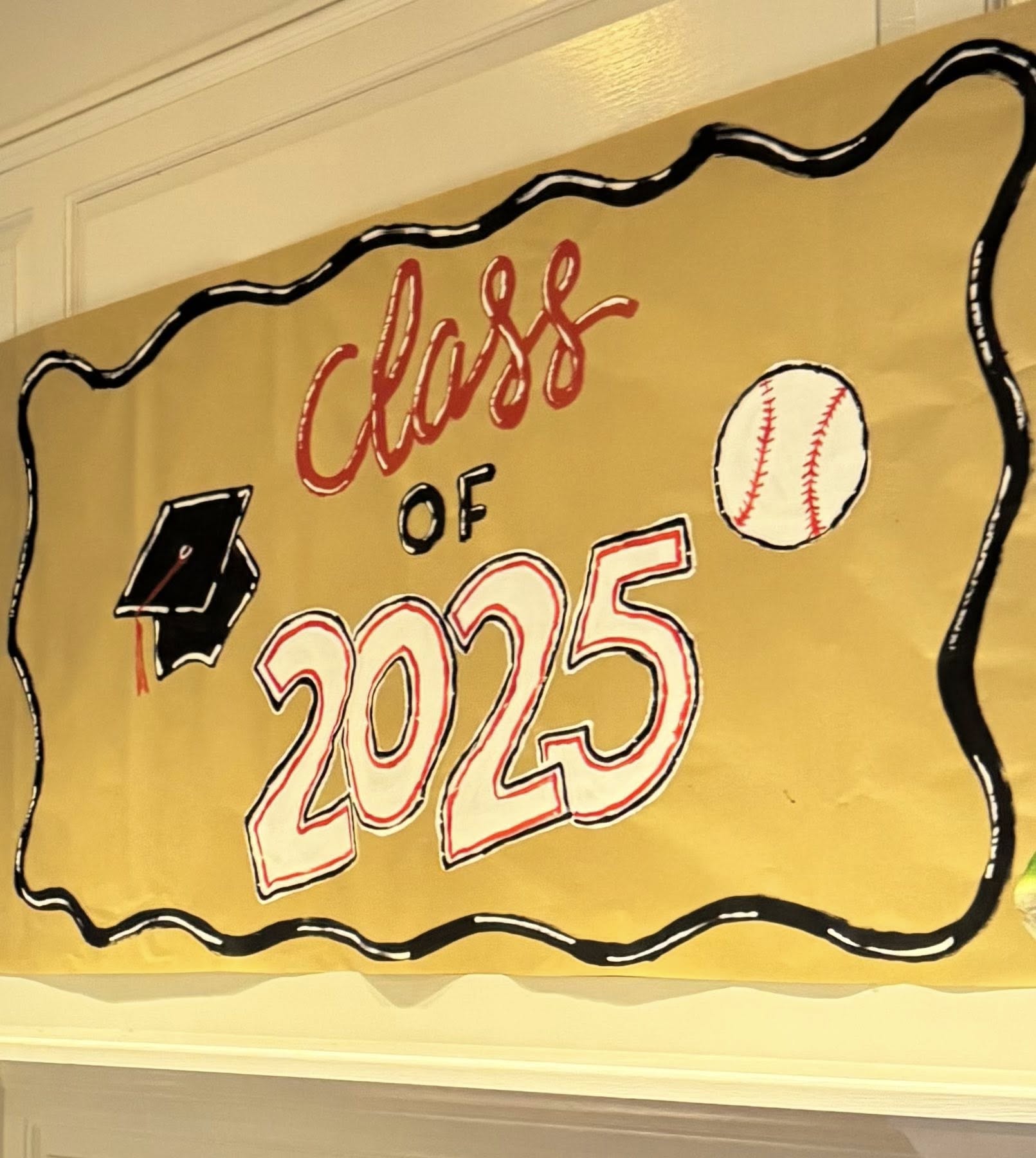 Hand-painted gold graduation banner reading Class of 2025 with illustrations of a mortarboard and a baseball.