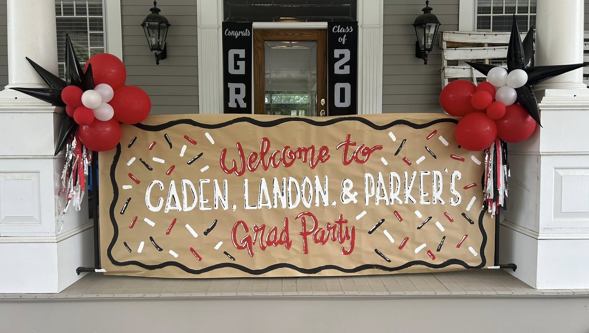 Graduation party welcome banner for Caden, Landon, and Parker decorated with red, white, and black balloons.