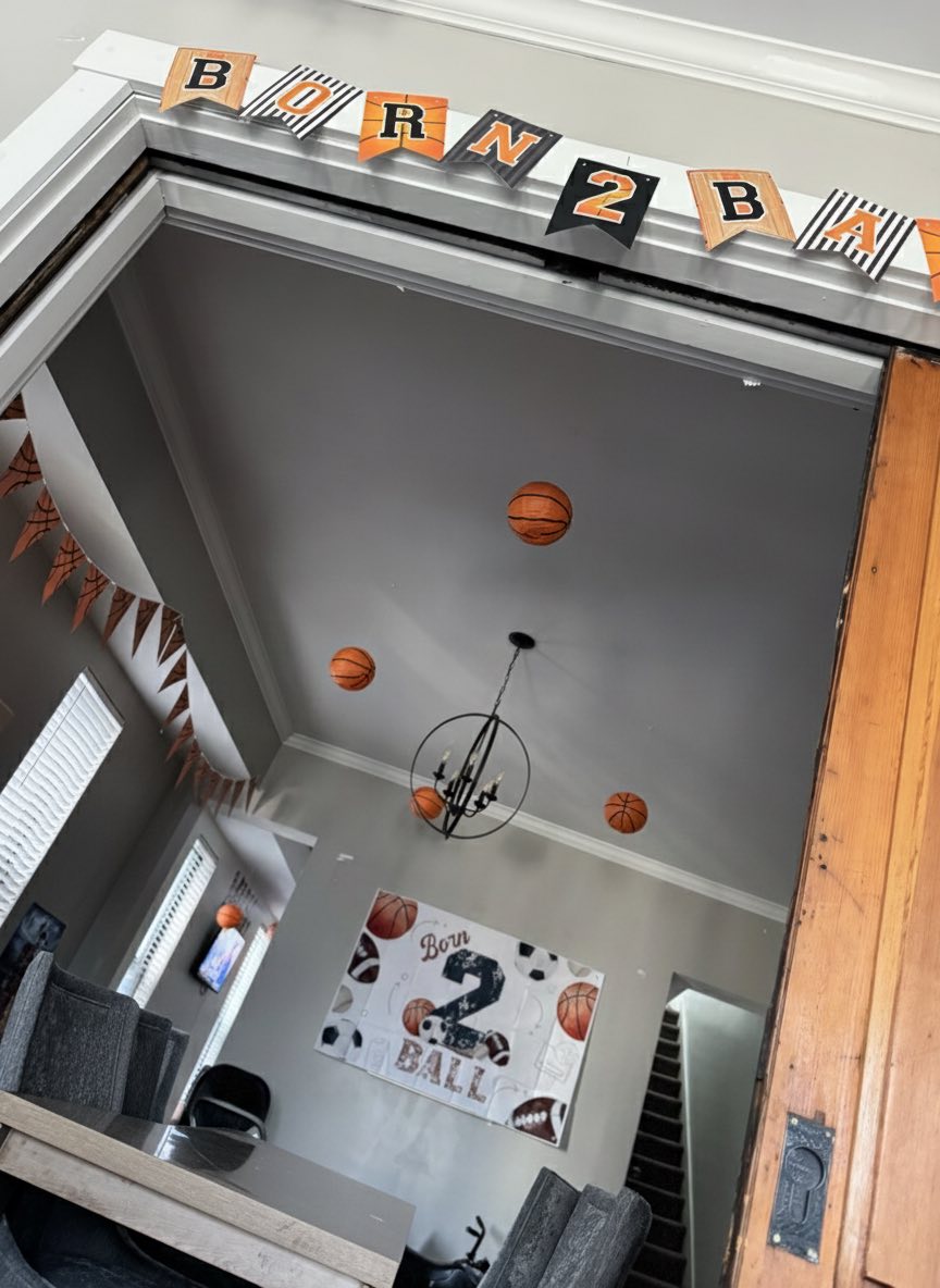 Basketball-themed party decorations including a Born 2 Ball banner and hanging basketballs.