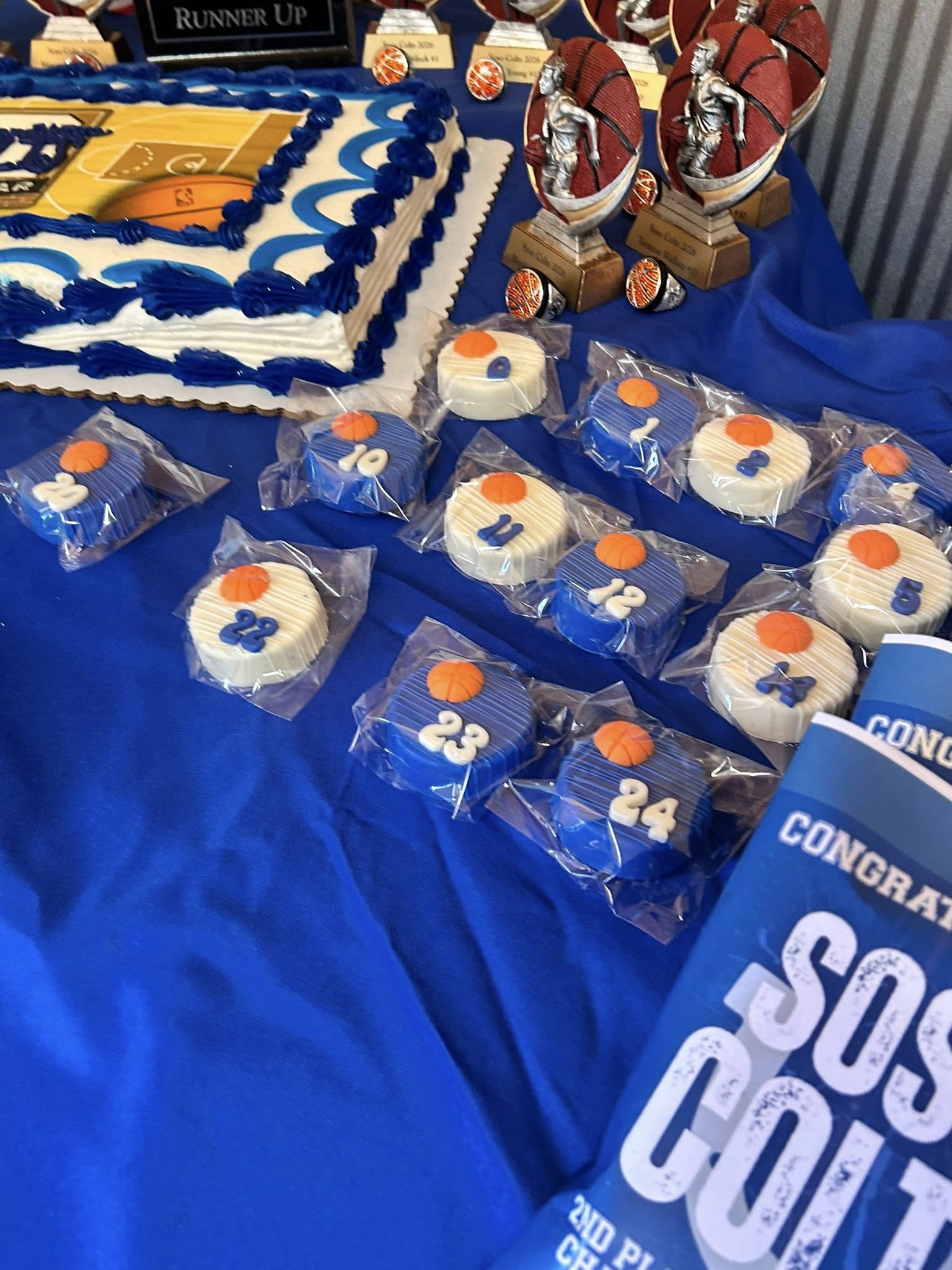 Basketball-themed sheet cake with individually wrapped sandwich cookies decorated with player jersey numbers.