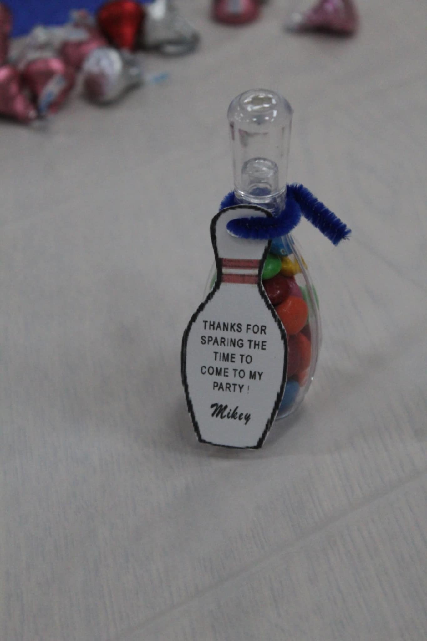 Bowling pin-shaped party favor bottle filled with colorful candy, featuring a tag saying Thanks for sparing the time