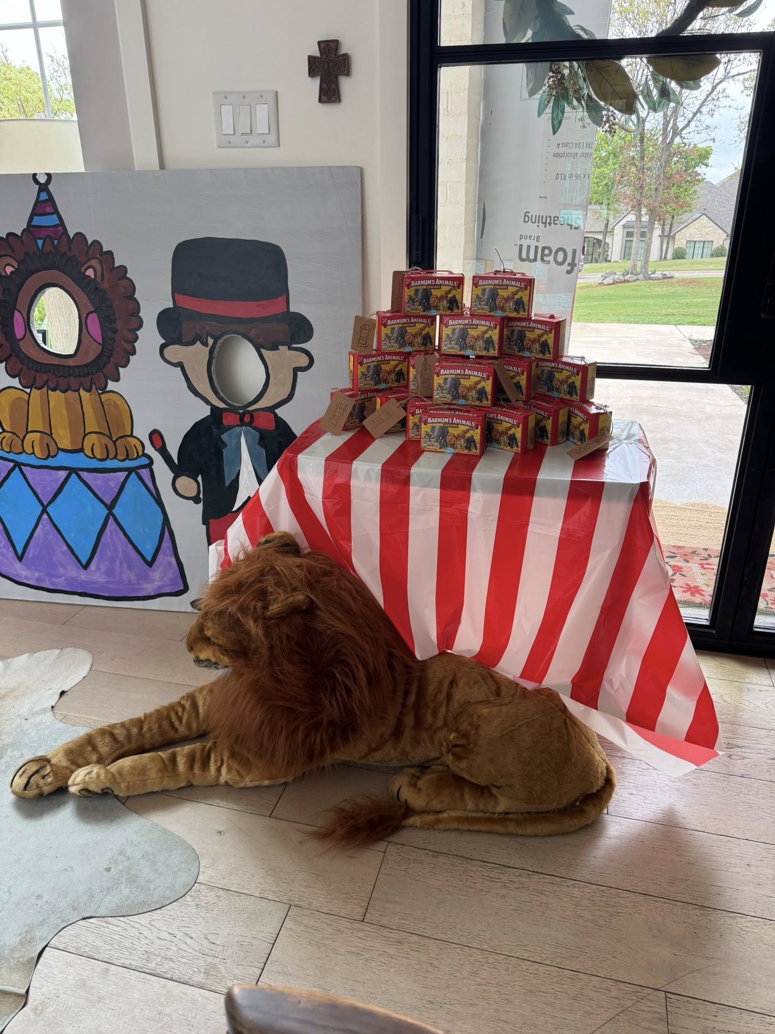 Table topped with stack of Barnum's Animal Crackers boxes and a stuffed lion toy underneath for a circus party.