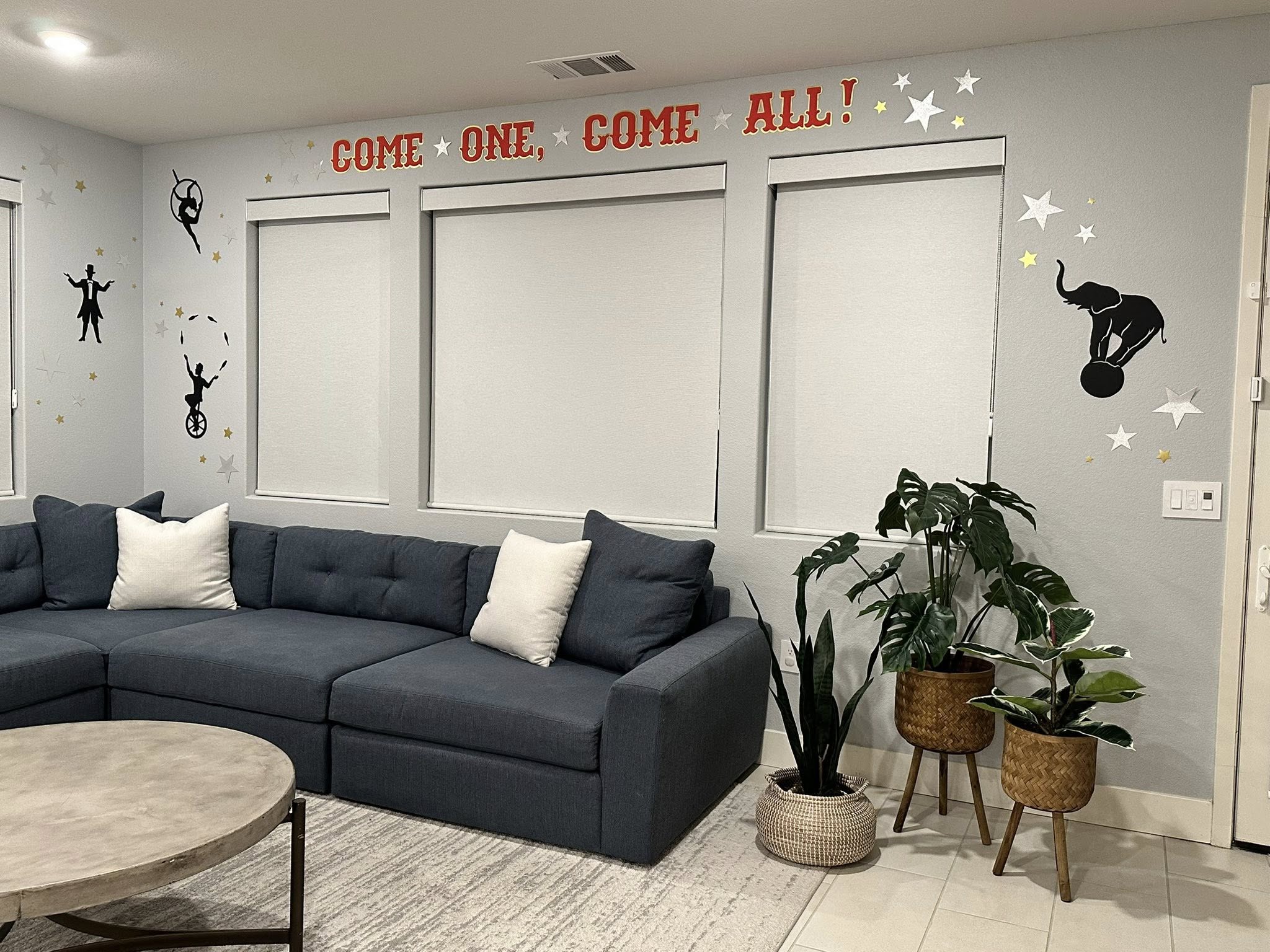 Living room wall decorated with circus theme wall decals including text reading Come One, Come All.