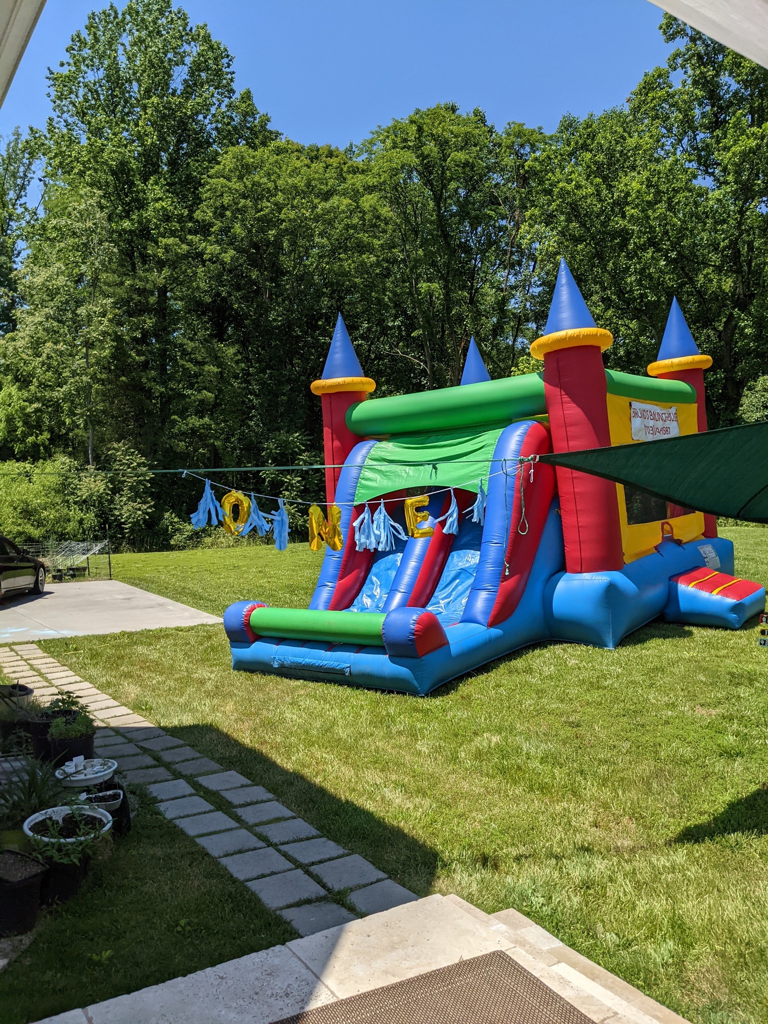 Colorful inflatable bounce house with slide set up on a backyard lawn